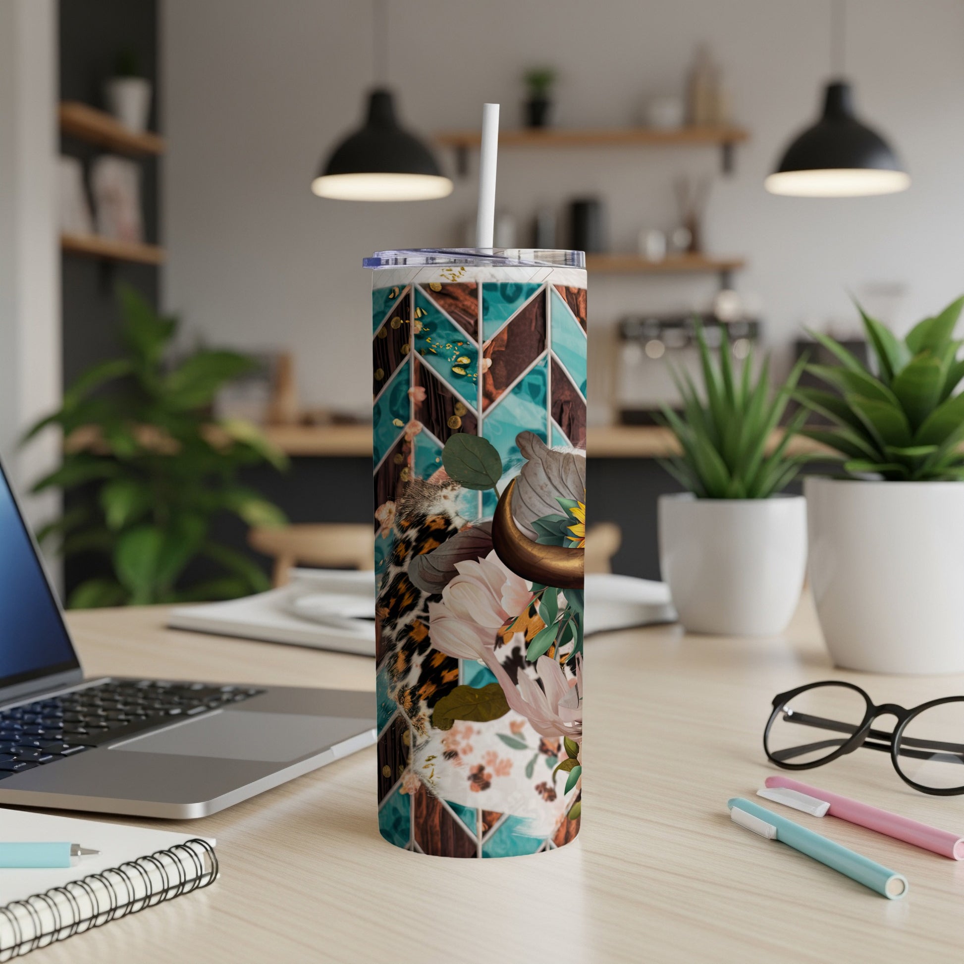 Abstract patterned tumbler with floral and leopard print, on a desk.