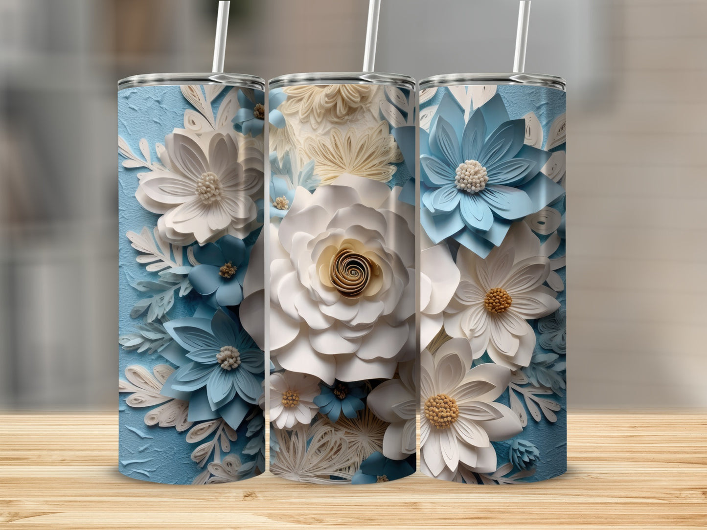 Three blue and white floral tumblers on a wooden surface.