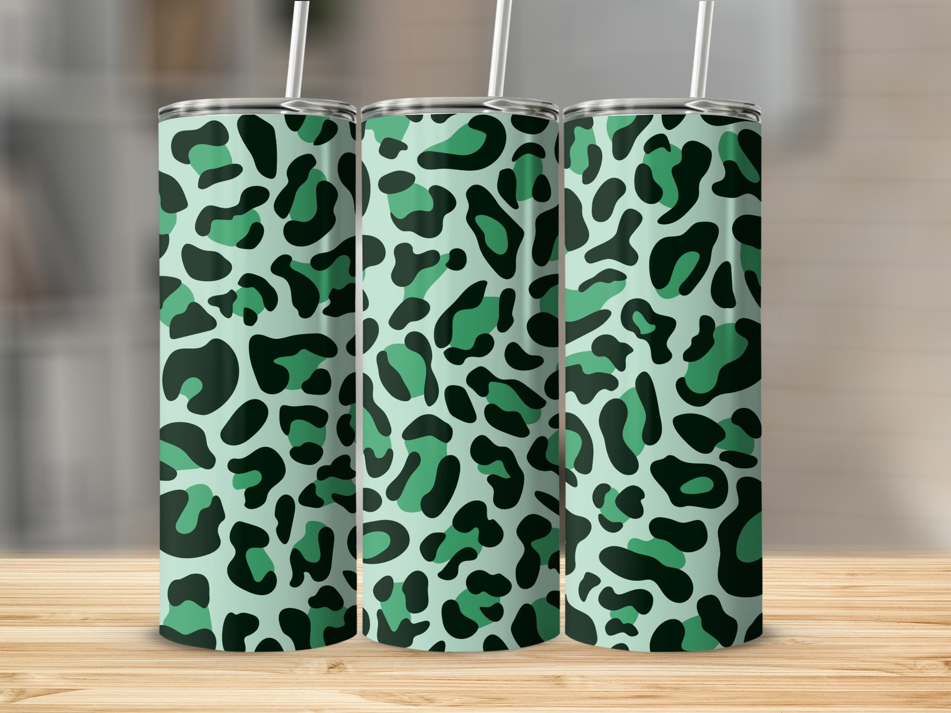 Three tall tumblers with a mint green and dark green leopard print pattern.