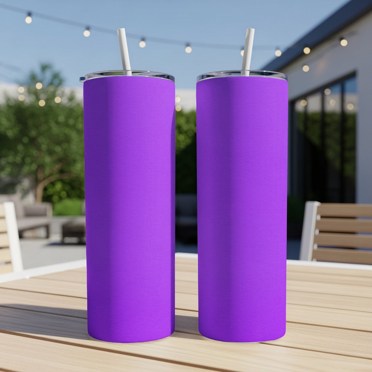 Two bright purple tumblers with white straws stand on a wooden table outdoors.