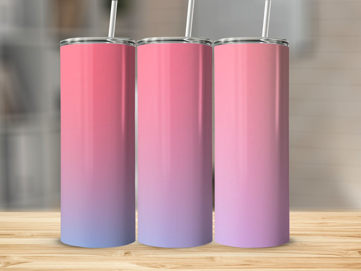 Three tumblers with pink to purple gradient and white straws on wooden surface.