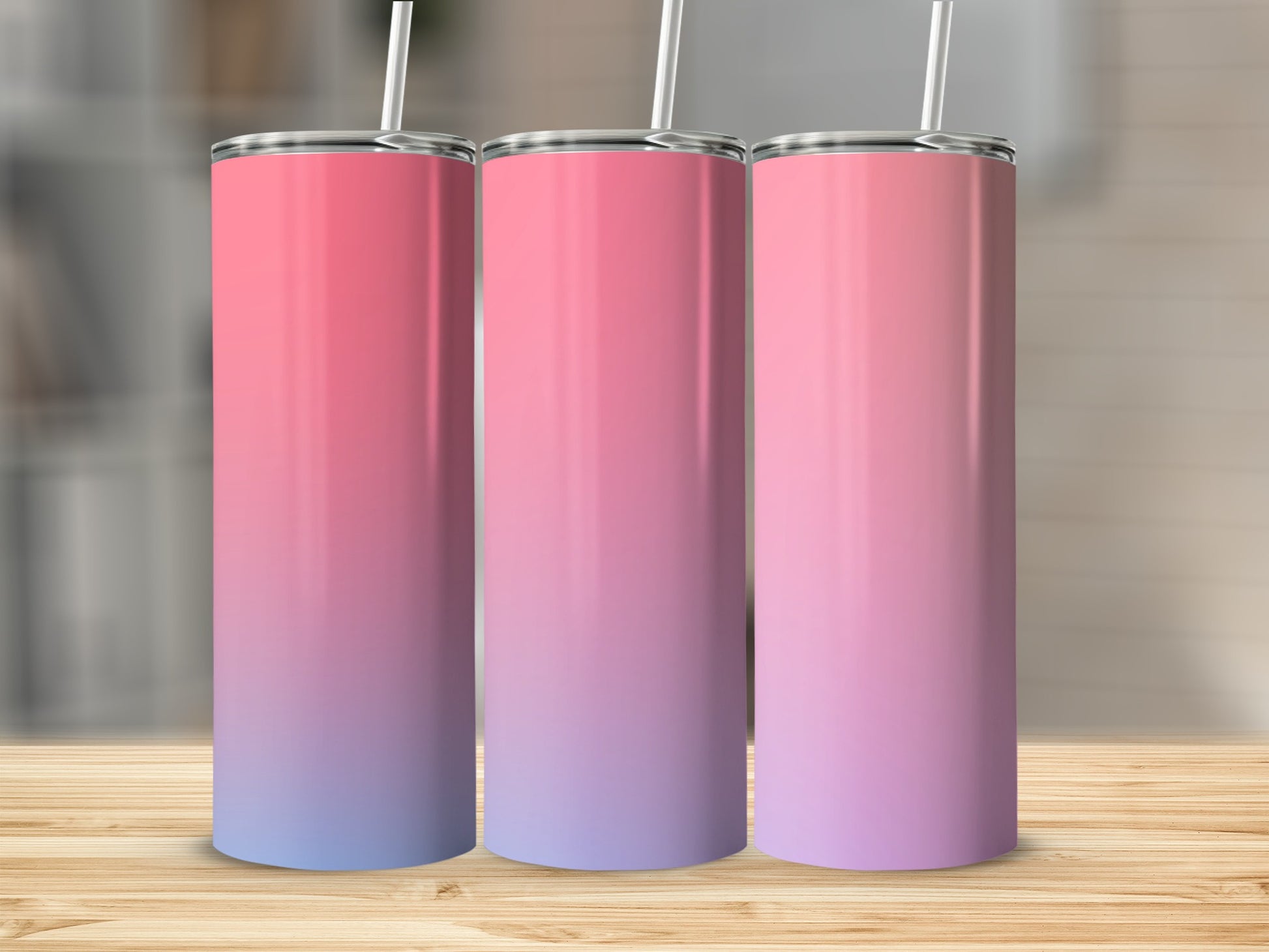 Three tumblers with pink to purple gradient and white straws on wooden surface.