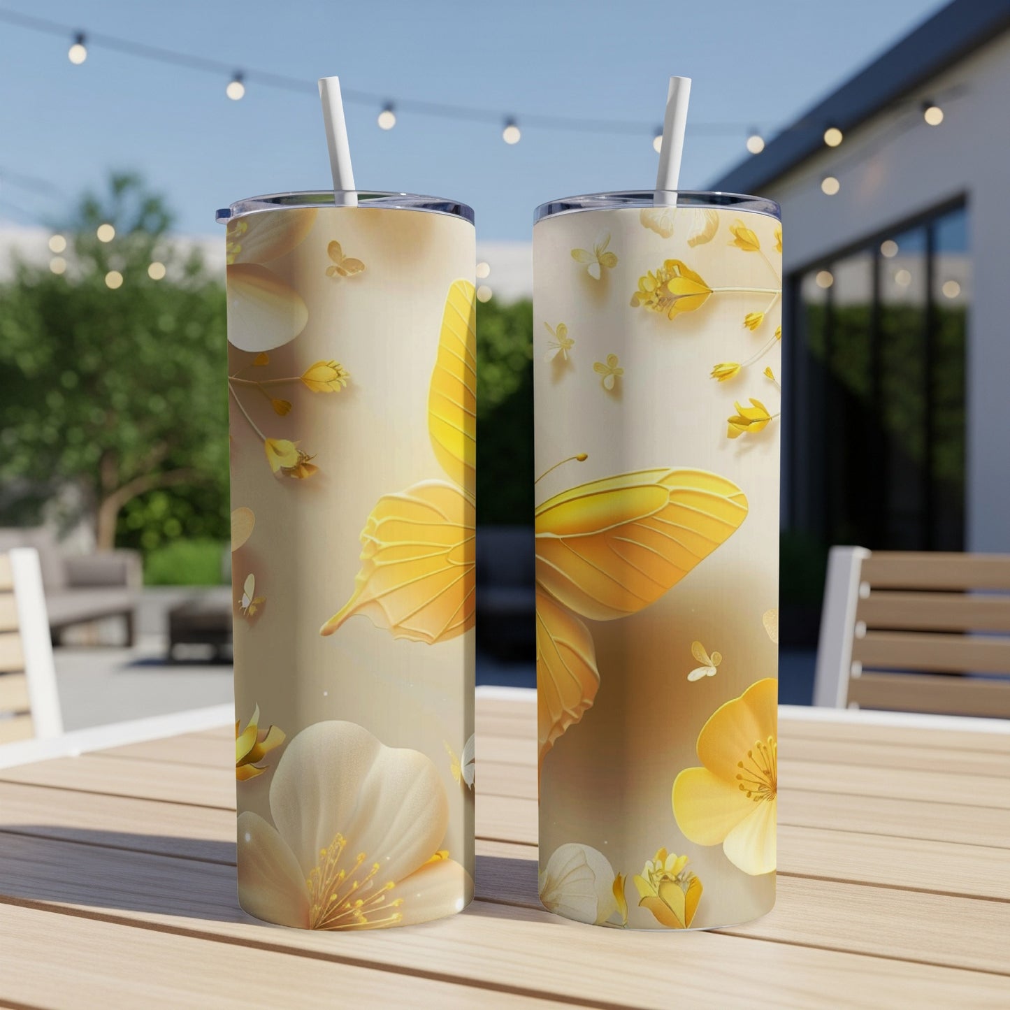 Two tumblers with a yellow butterfly and floral design on a patio table.