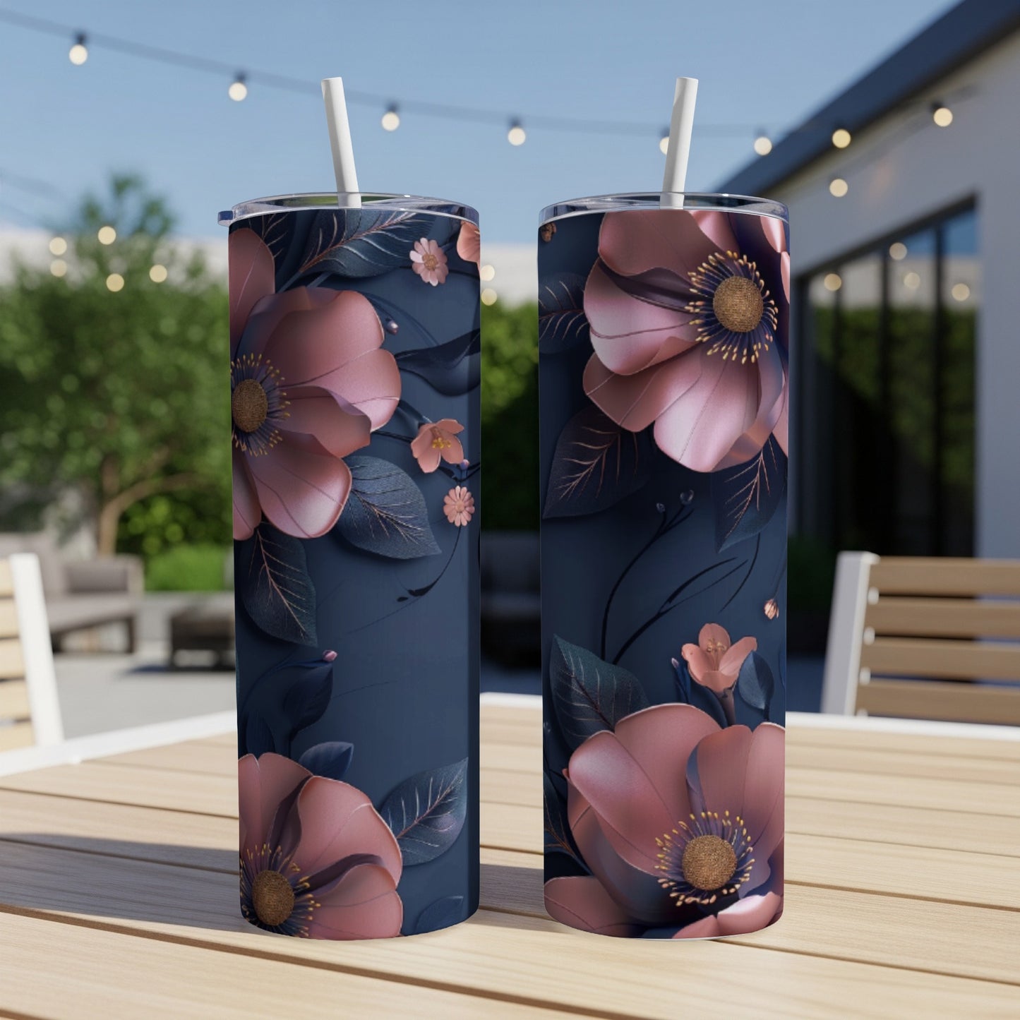 Two dark blue tumblers with large pink floral designs and straws.
