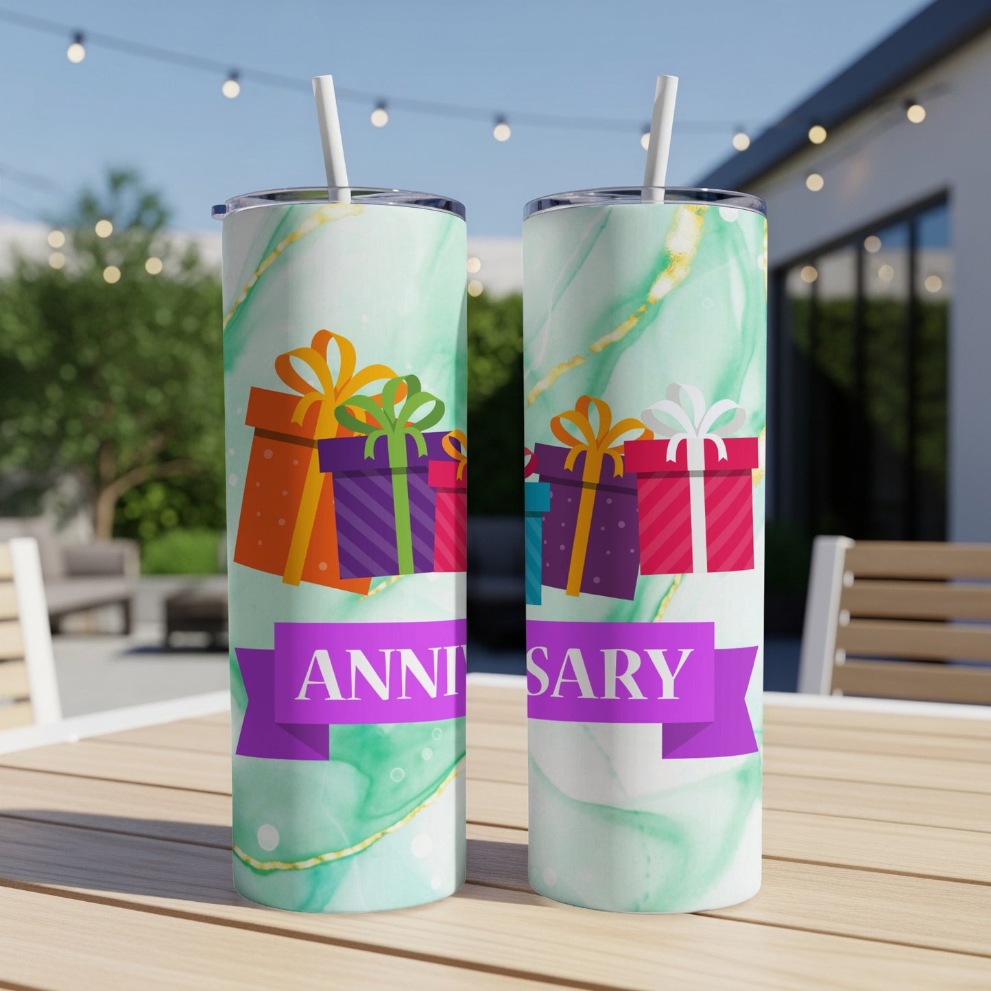 Two patterned tumblers with gift boxes and "Anniversary" text on a table.