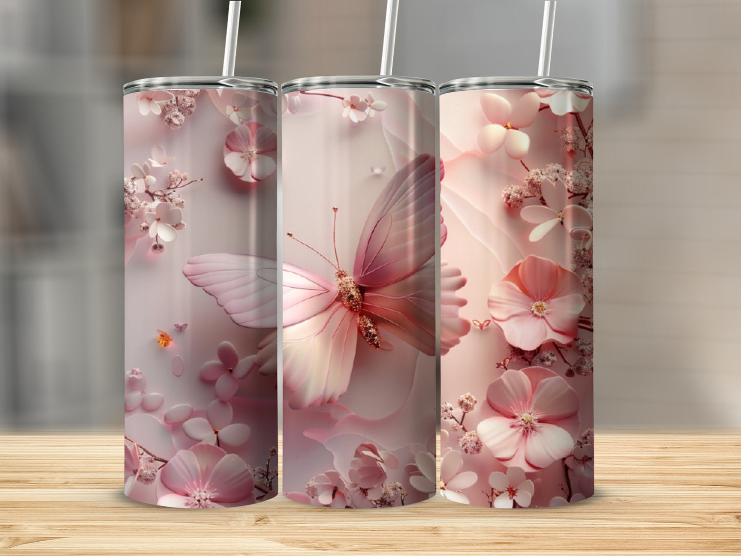 Pink floral and butterfly patterned tumblers with straws on a wooden surface.