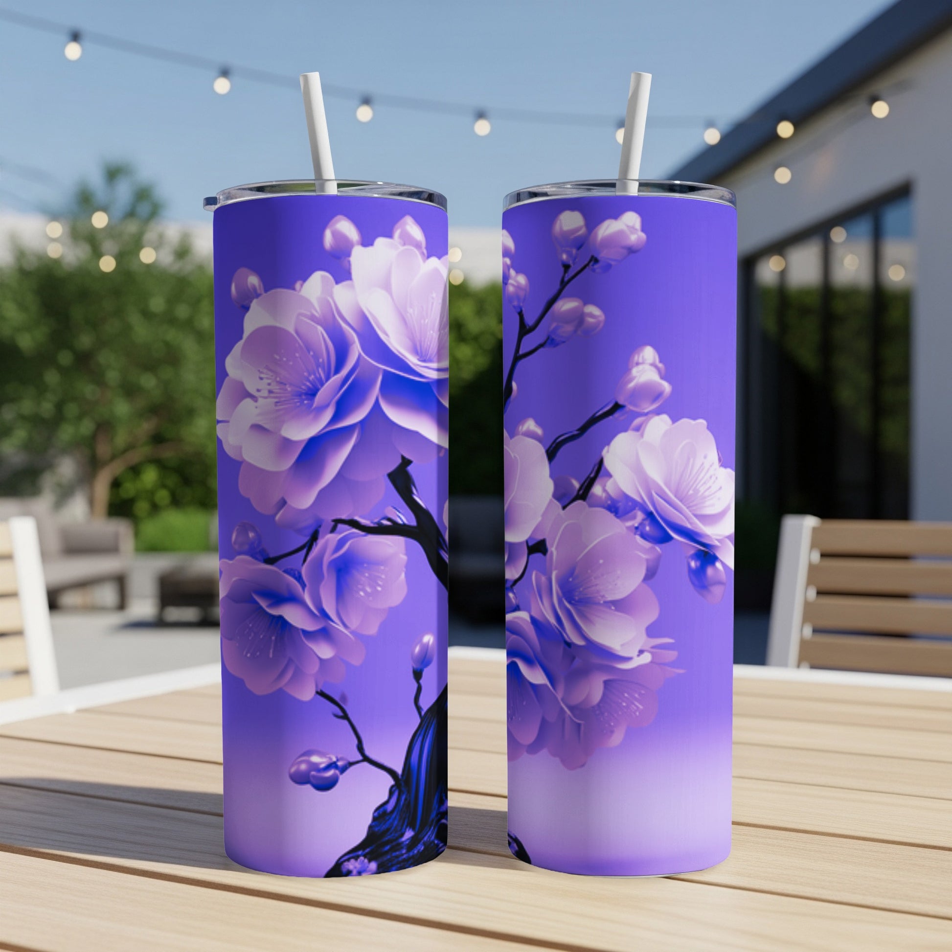 Two purple tumblers with a delicate cherry blossom design sit on a wooden table outdoors.