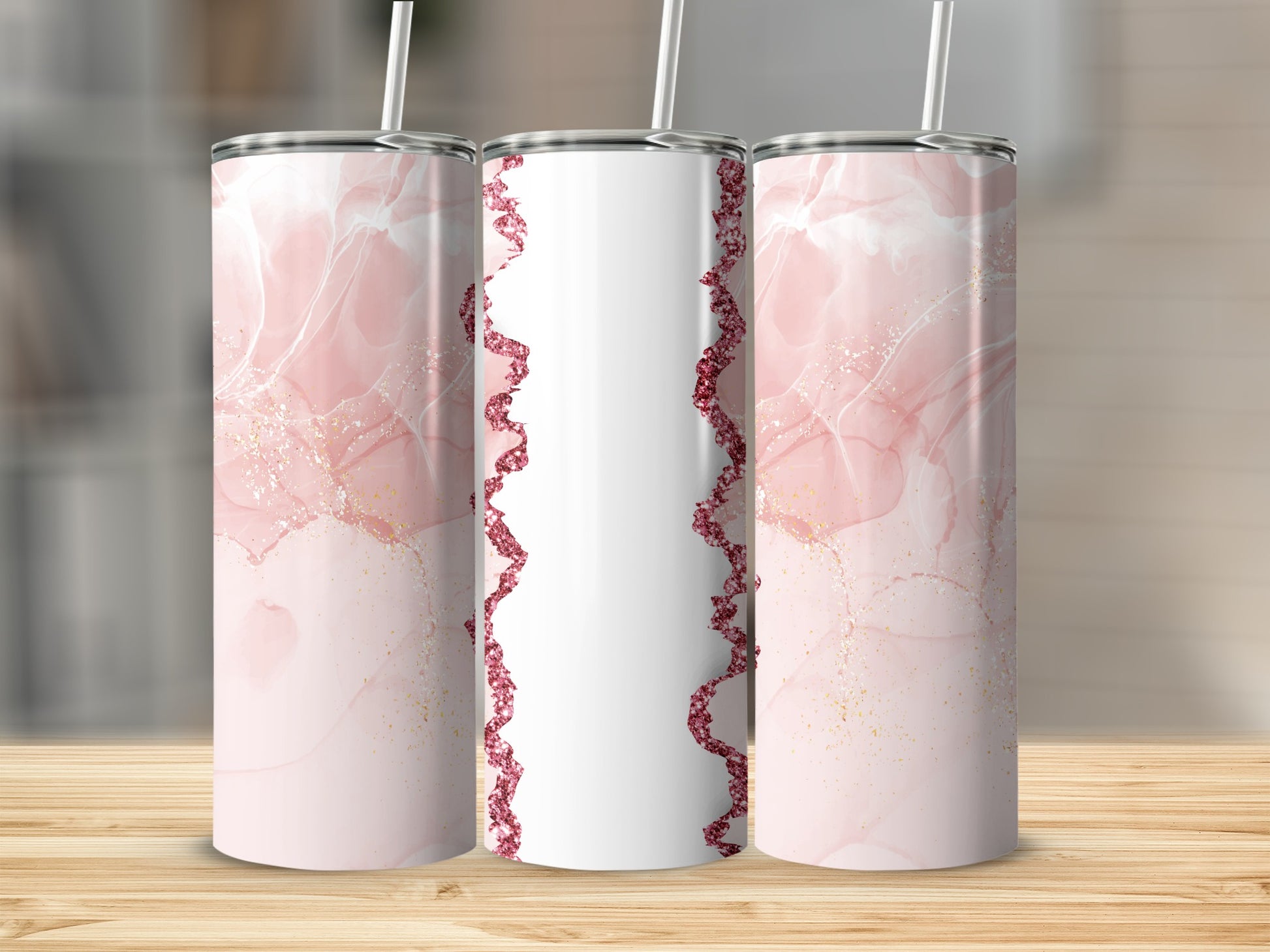 Pink marble tumblers with sparkly white and gold accents on wooden surface.