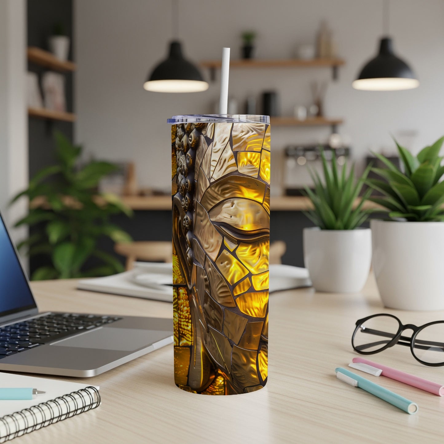Gold mosaic Buddha face on a tall, insulated tumbler with a straw.