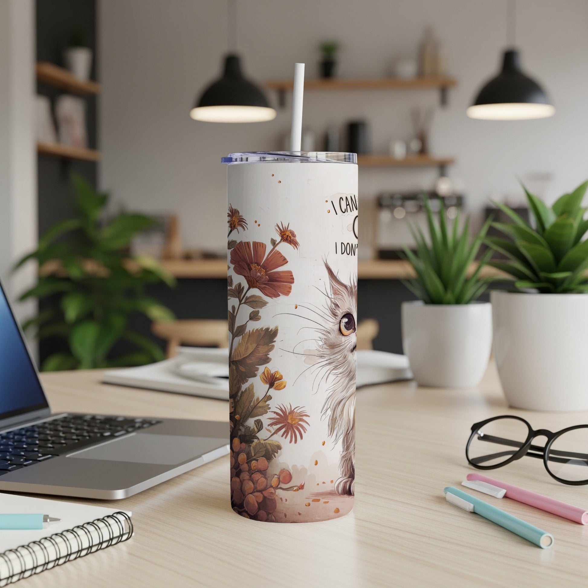 White tumbler with a cat illustration and text on a desk.