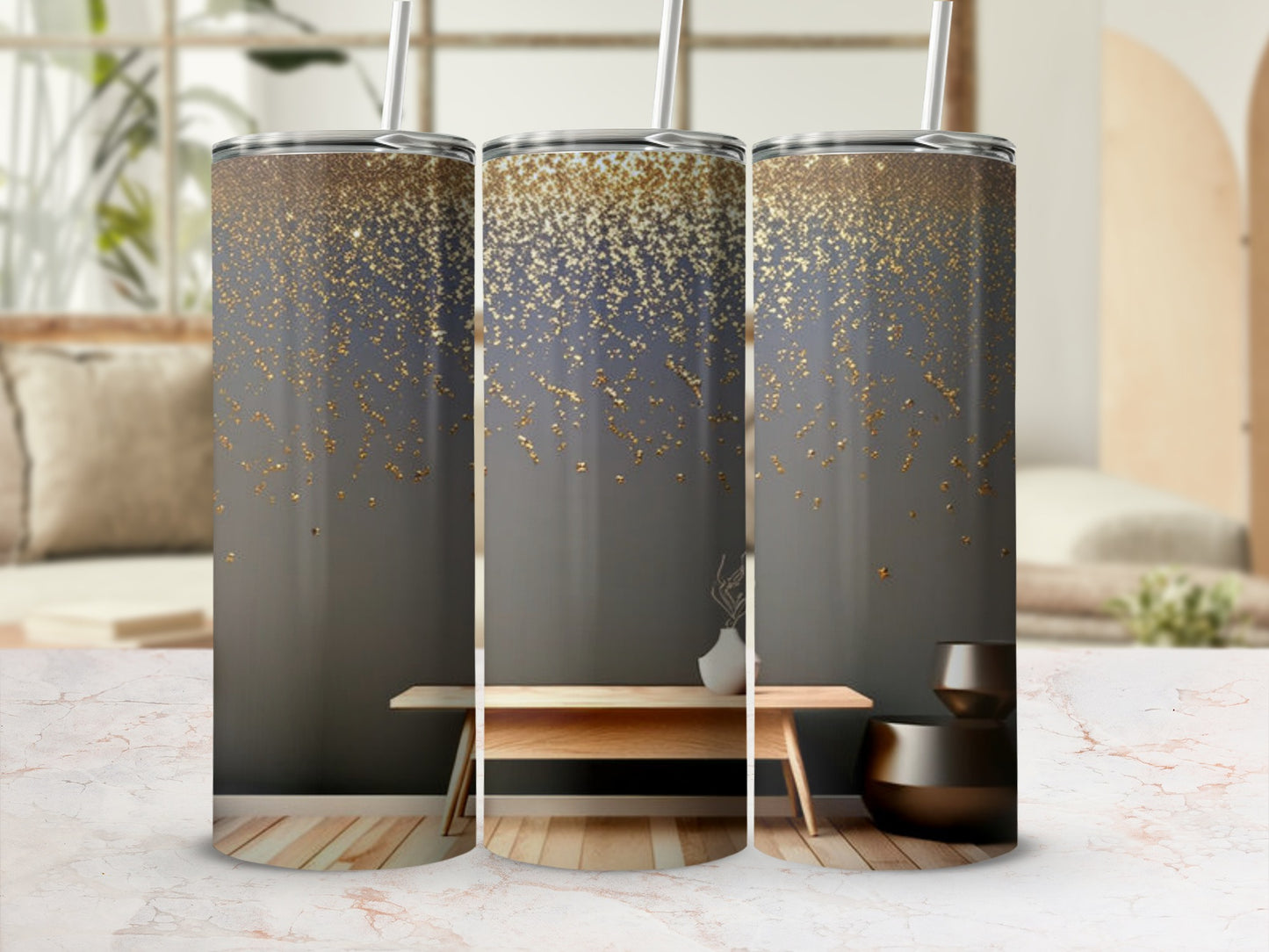 Three glitter-covered tumblers with straws on a table.