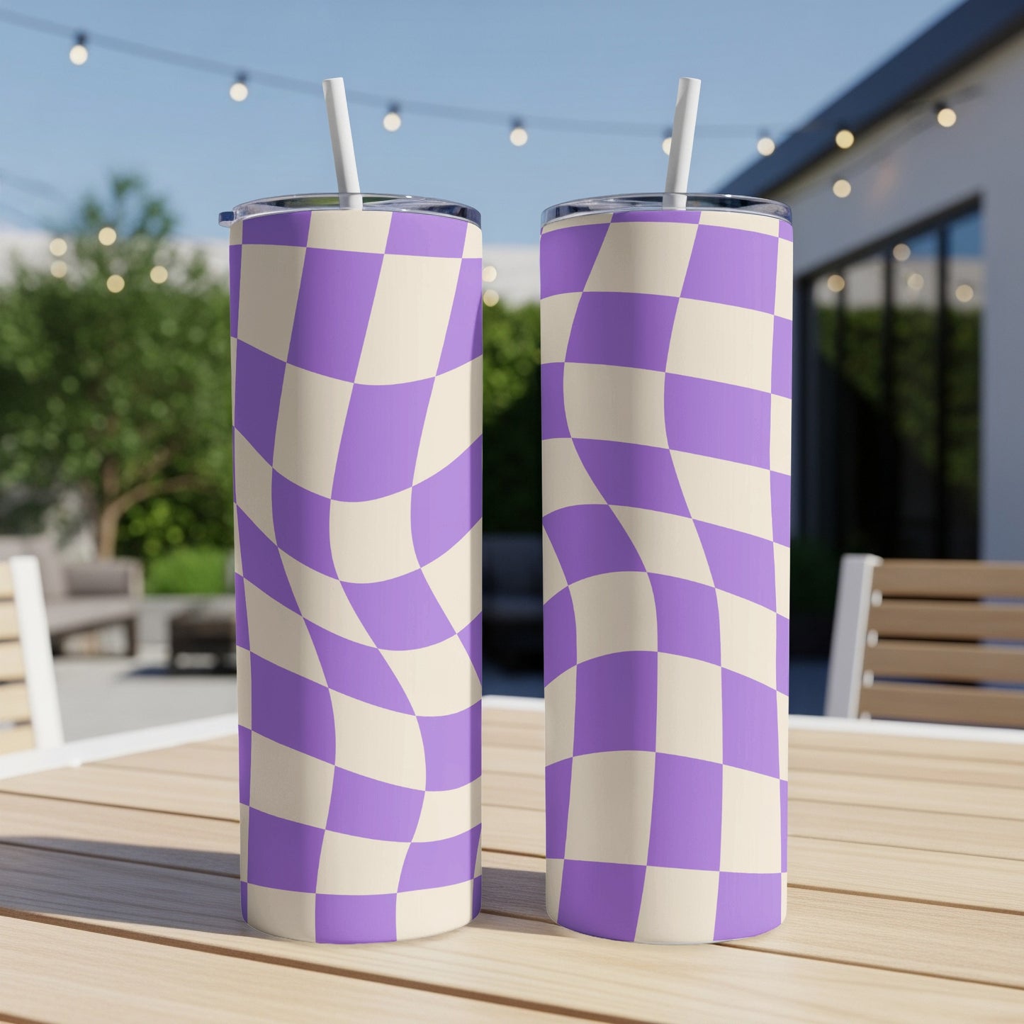Two tumblers with purple and cream checkerboard pattern on outdoor table.