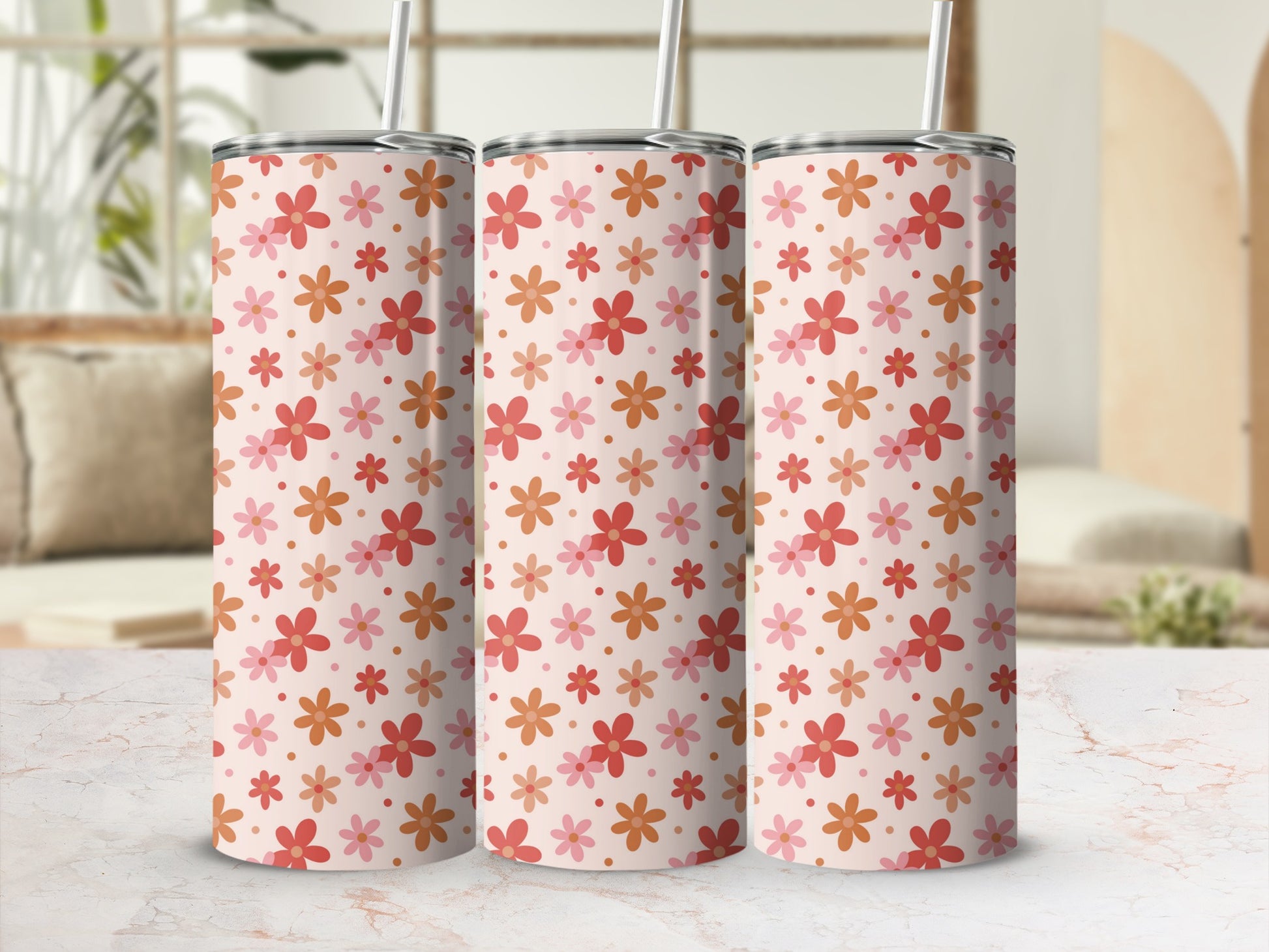 Three tall tumblers with a repeating pattern of small pink and orange flowers.