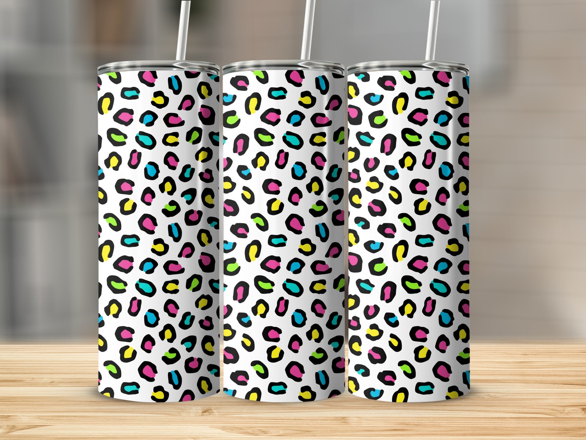 Three tumblers with a white background and colorful leopard print pattern.