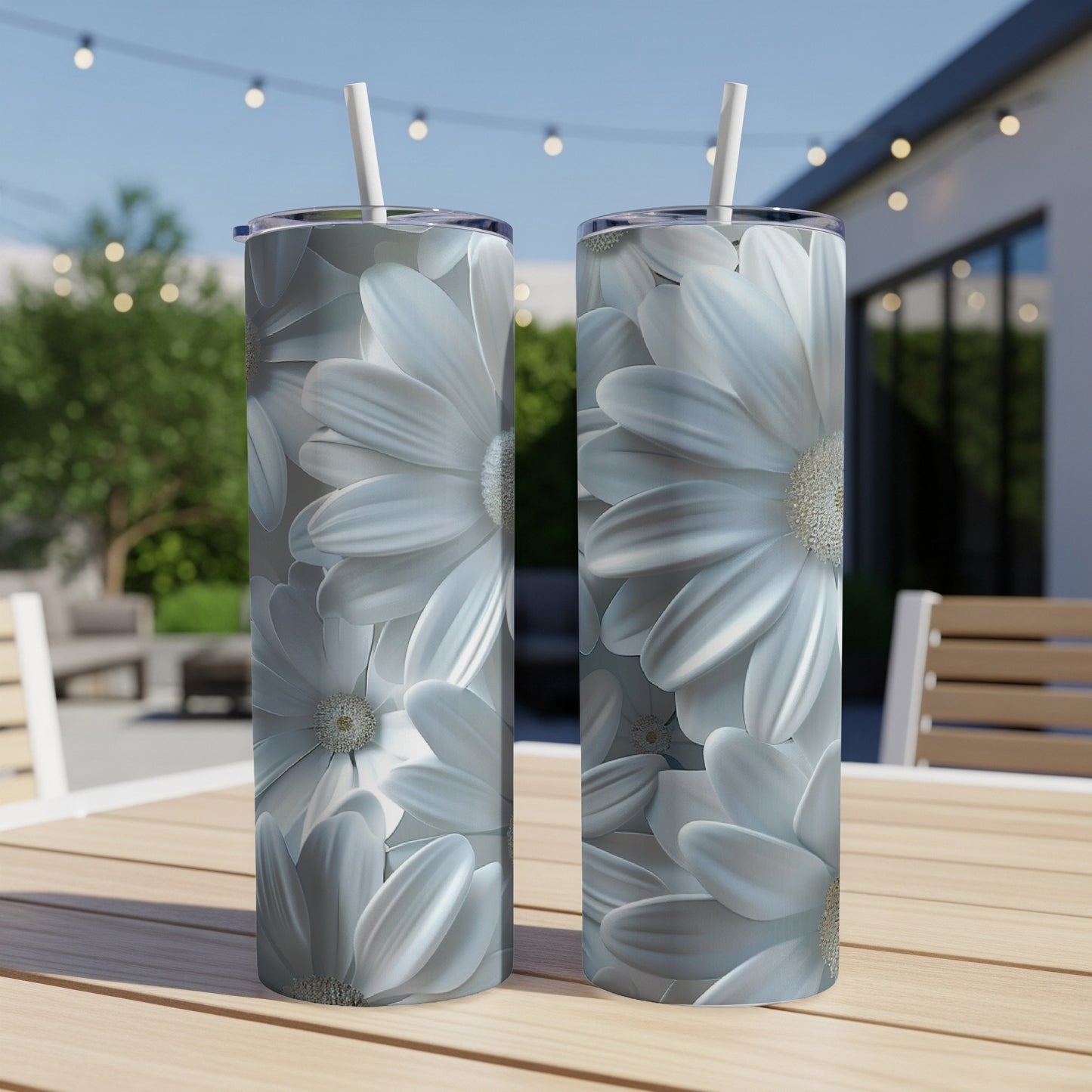 Two tumblers with a white daisy floral pattern on a wooden table.