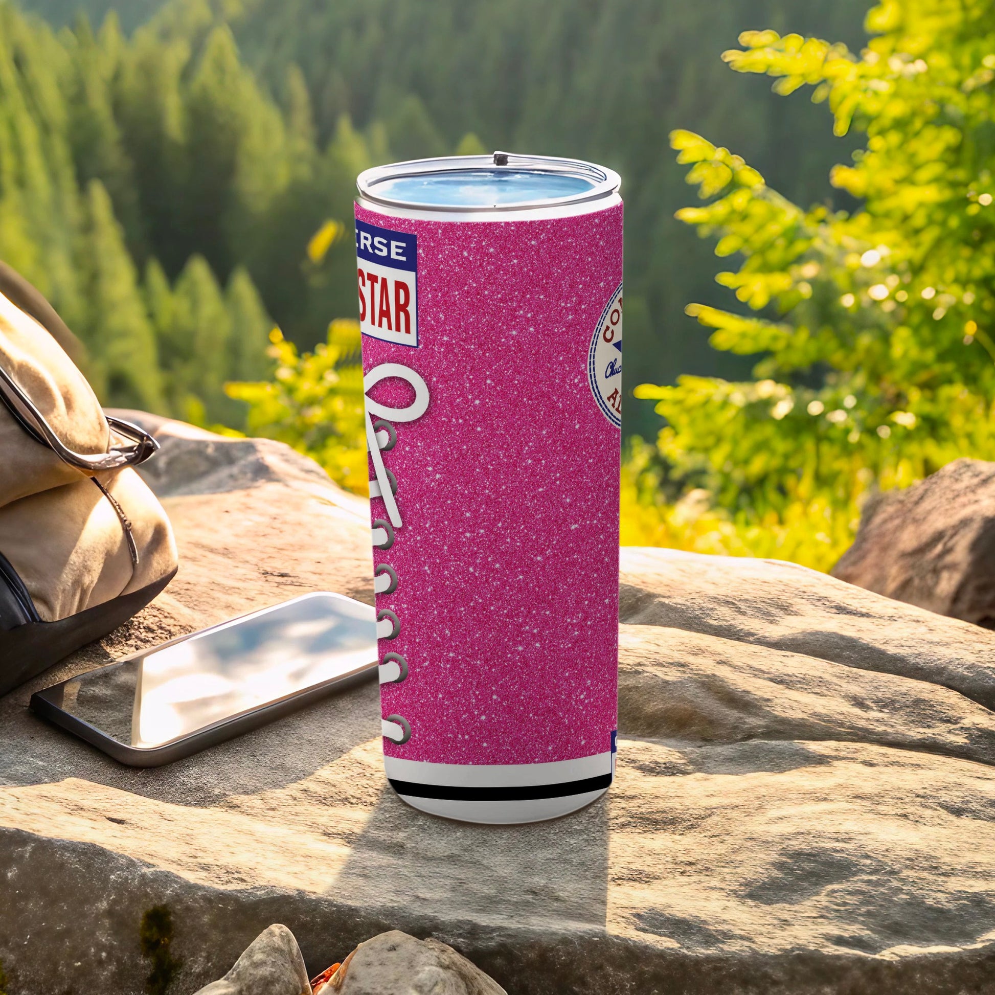 Pink glitter Converse tumbler with white laces against a rocky, outdoor background.