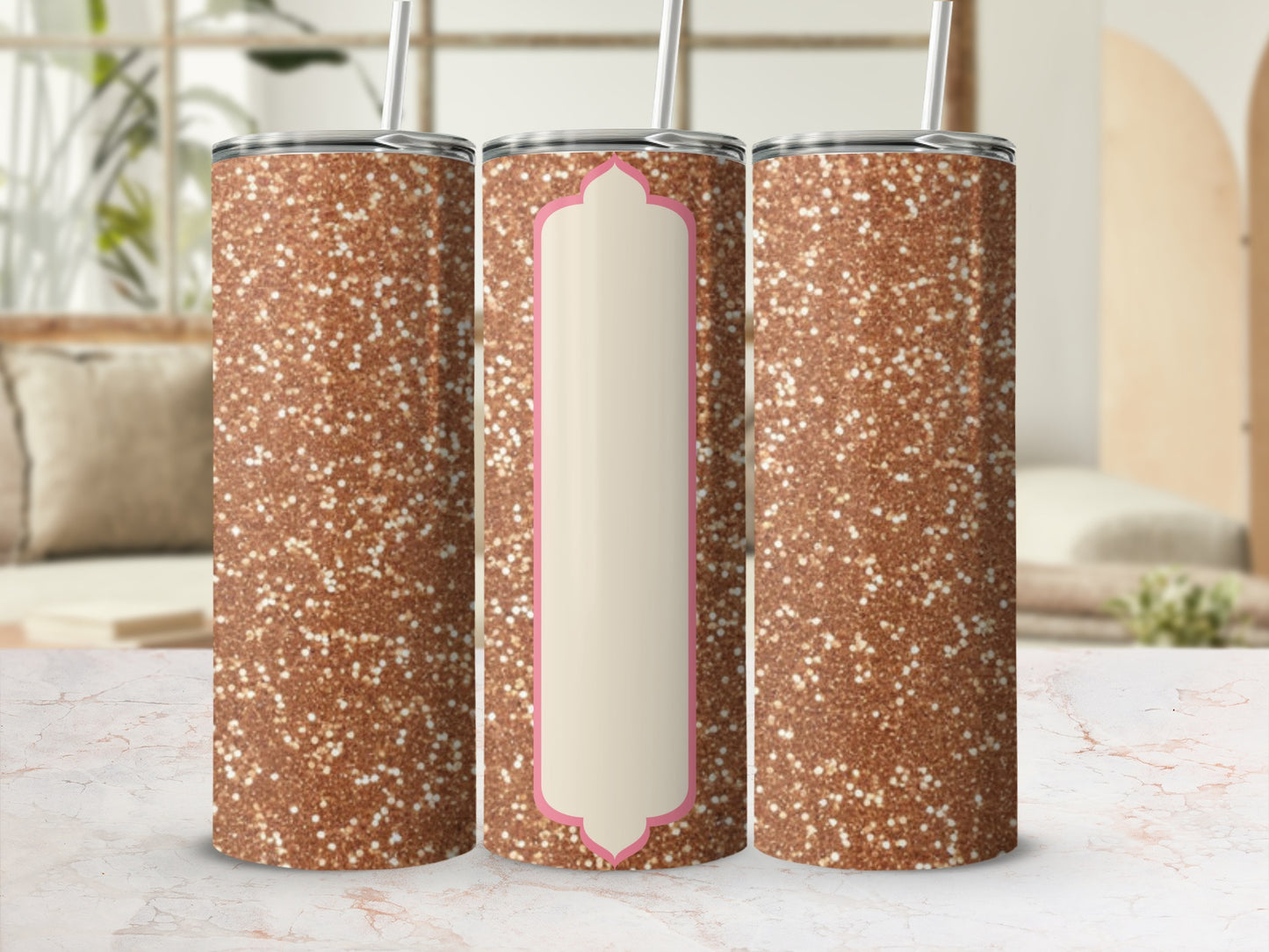 Three glitter tumblers with straw on a marble surface.