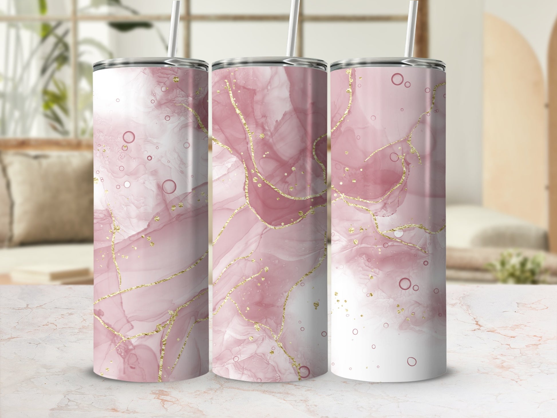 Three pink marble pattern tumblers with gold accents on a marble surface.