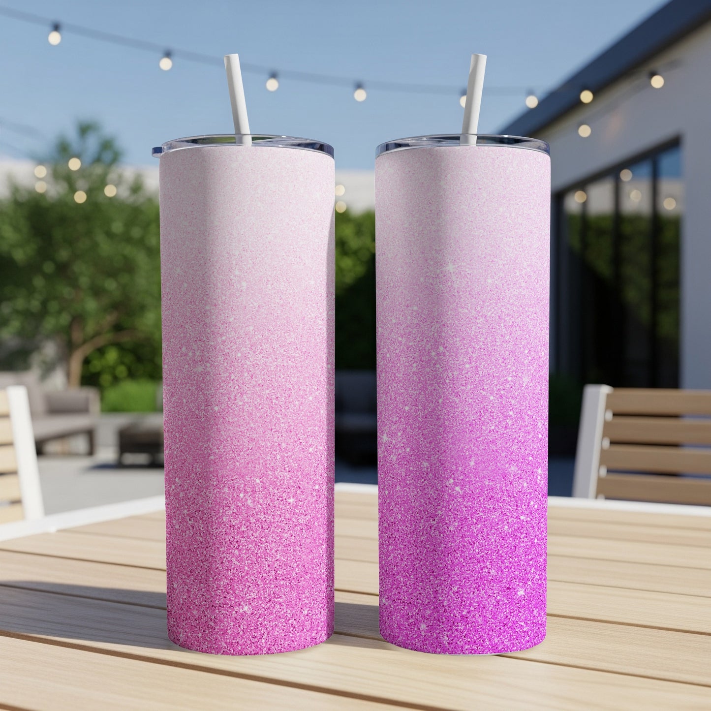 Two glitter tumblers with pink ombre gradient, each with a straw.