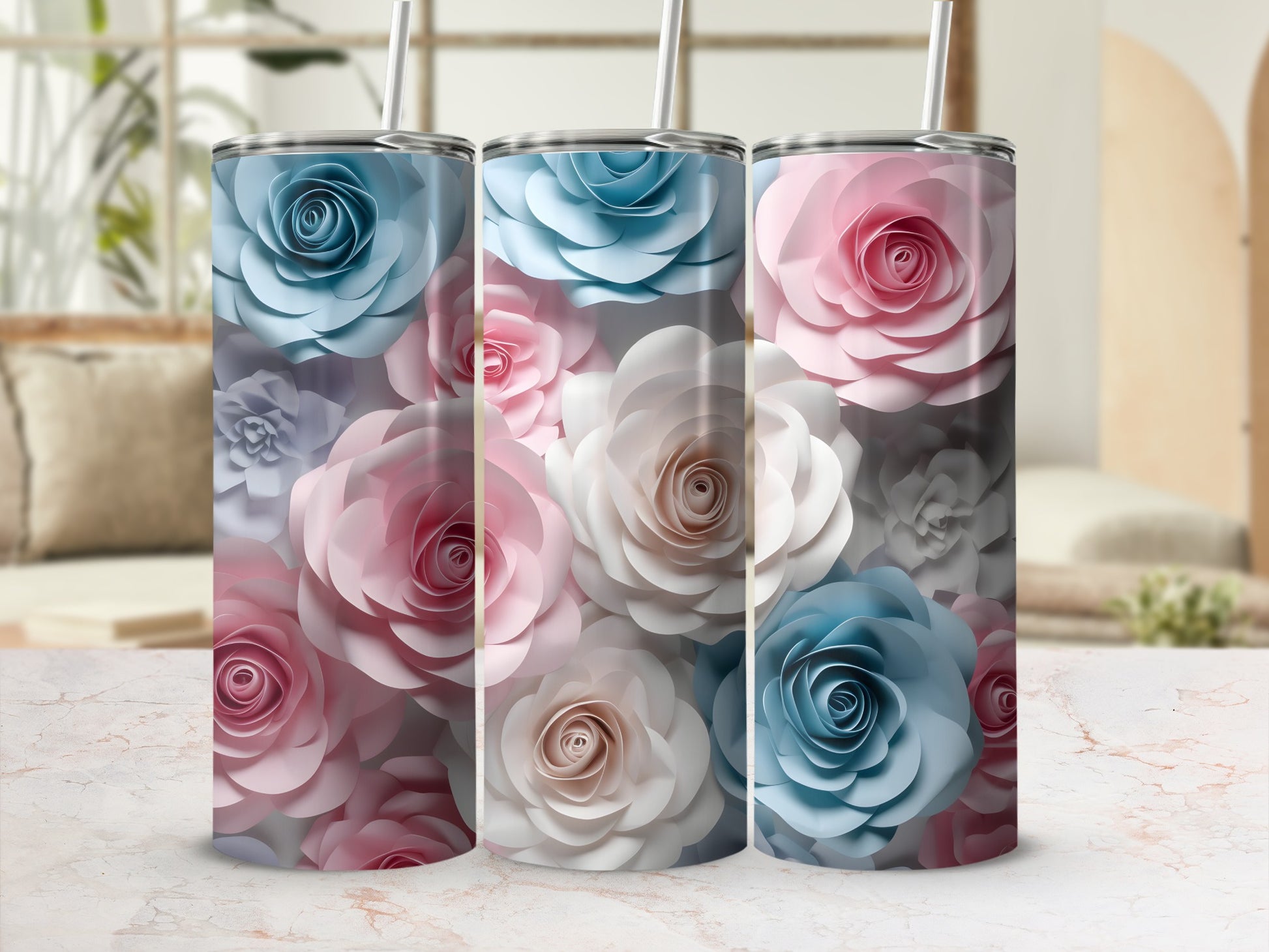 Three textured floral tumblers in pink, blue, and white sit on a marbled surface.