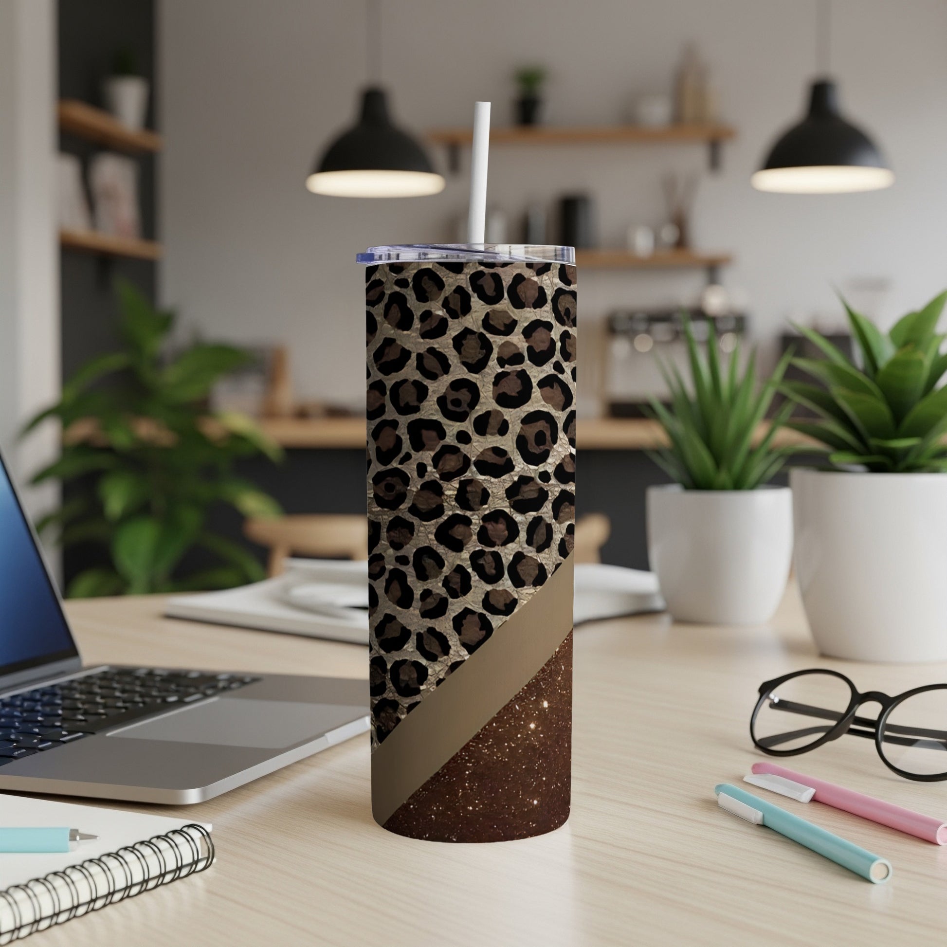 Leopard print tumbler with glitter accent and straw on a desk.