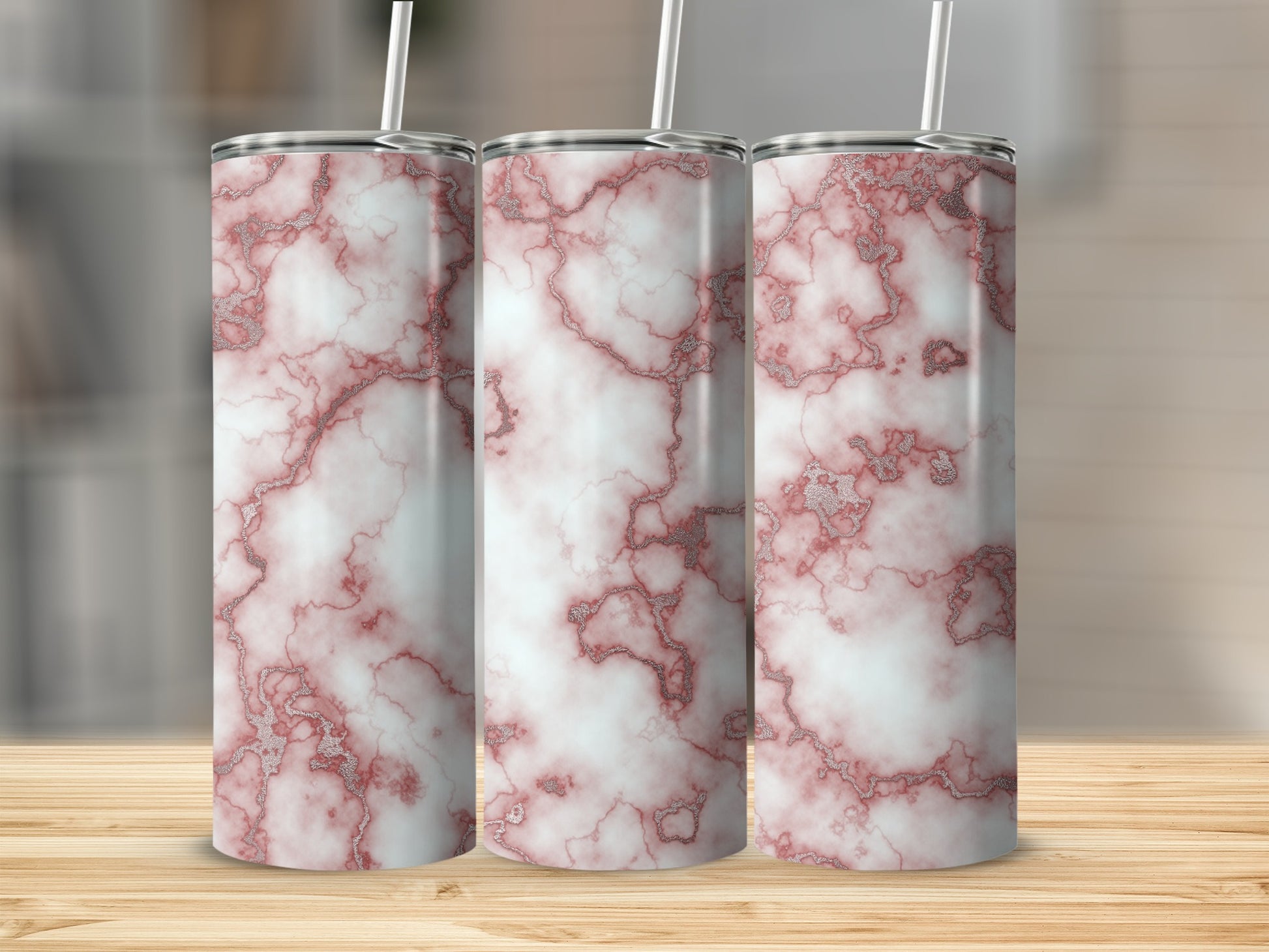 Three tumblers with a pink and white marble pattern on a wooden surface.