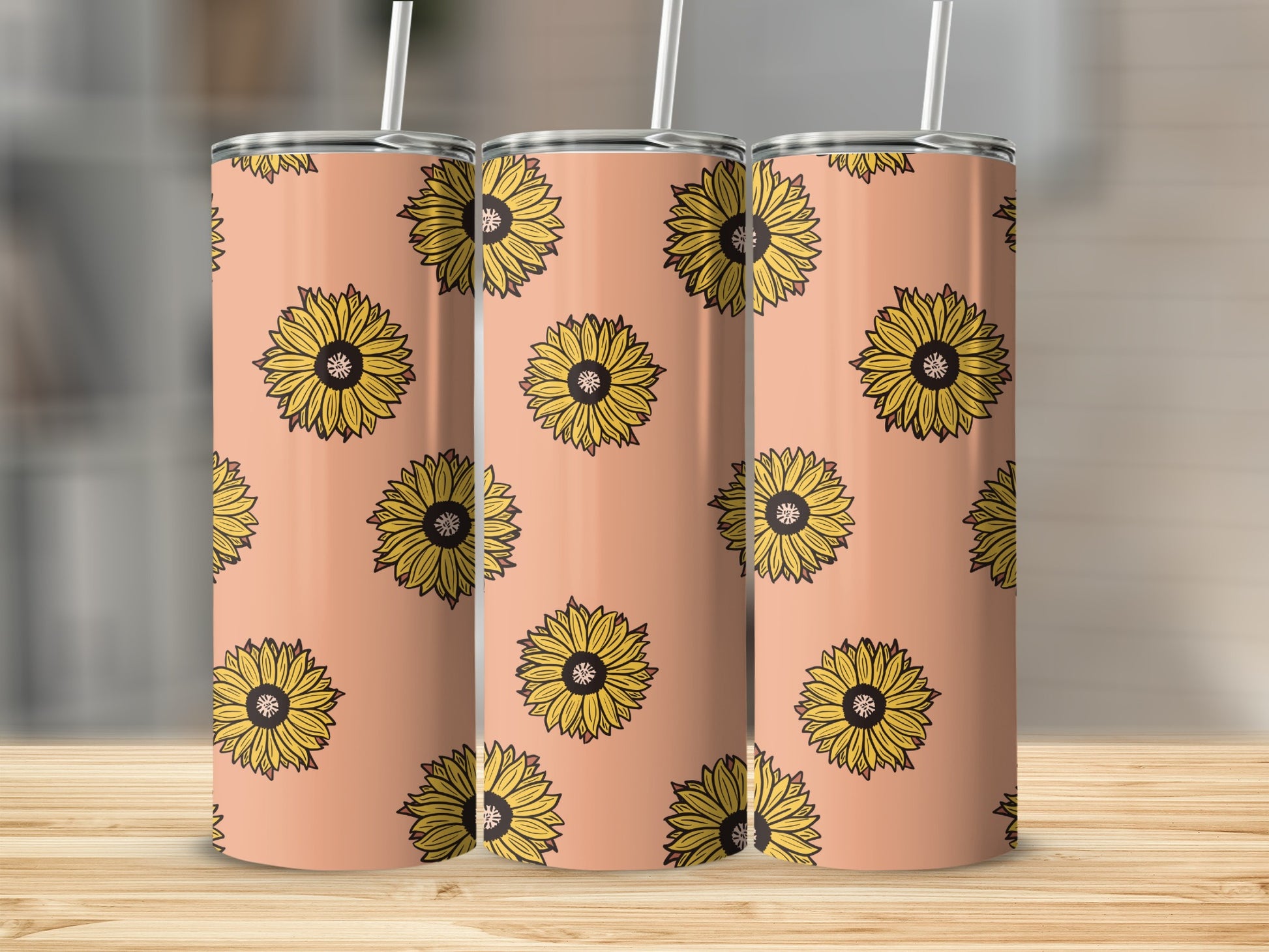 Three tumblers with a repeating pattern of yellow sunflowers on a salmon-colored background.