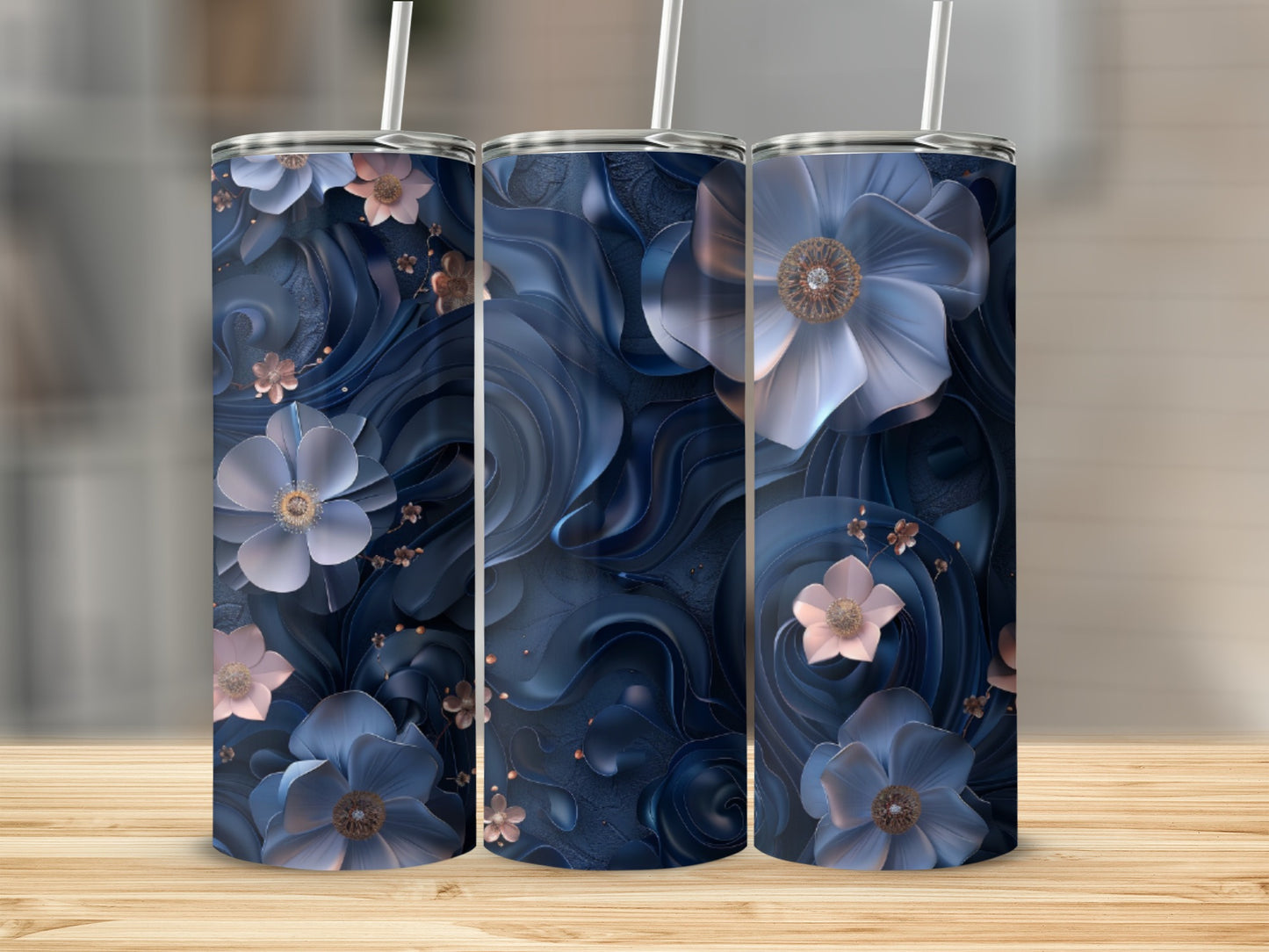 Three dark blue tumblers with floral designs on a wooden surface.