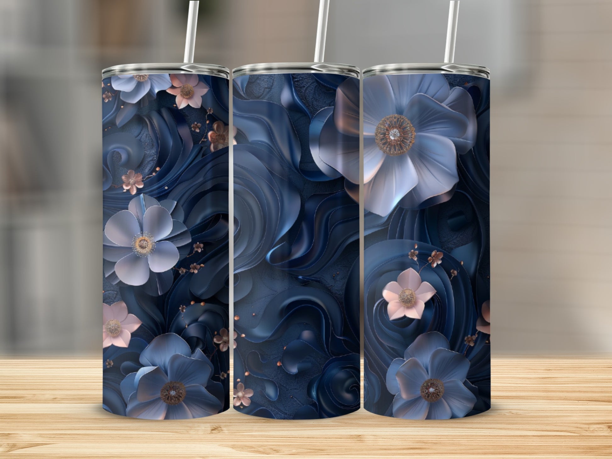 Three dark blue tumblers with floral designs on a wooden surface.