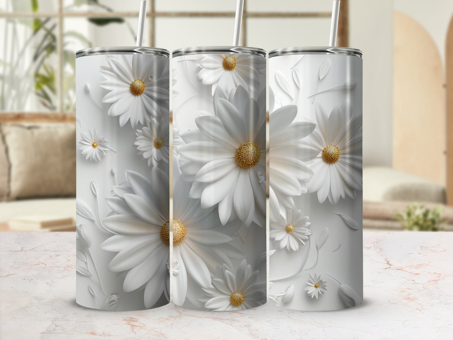 Three white daisy floral tumblers with straws displayed on a marble surface.