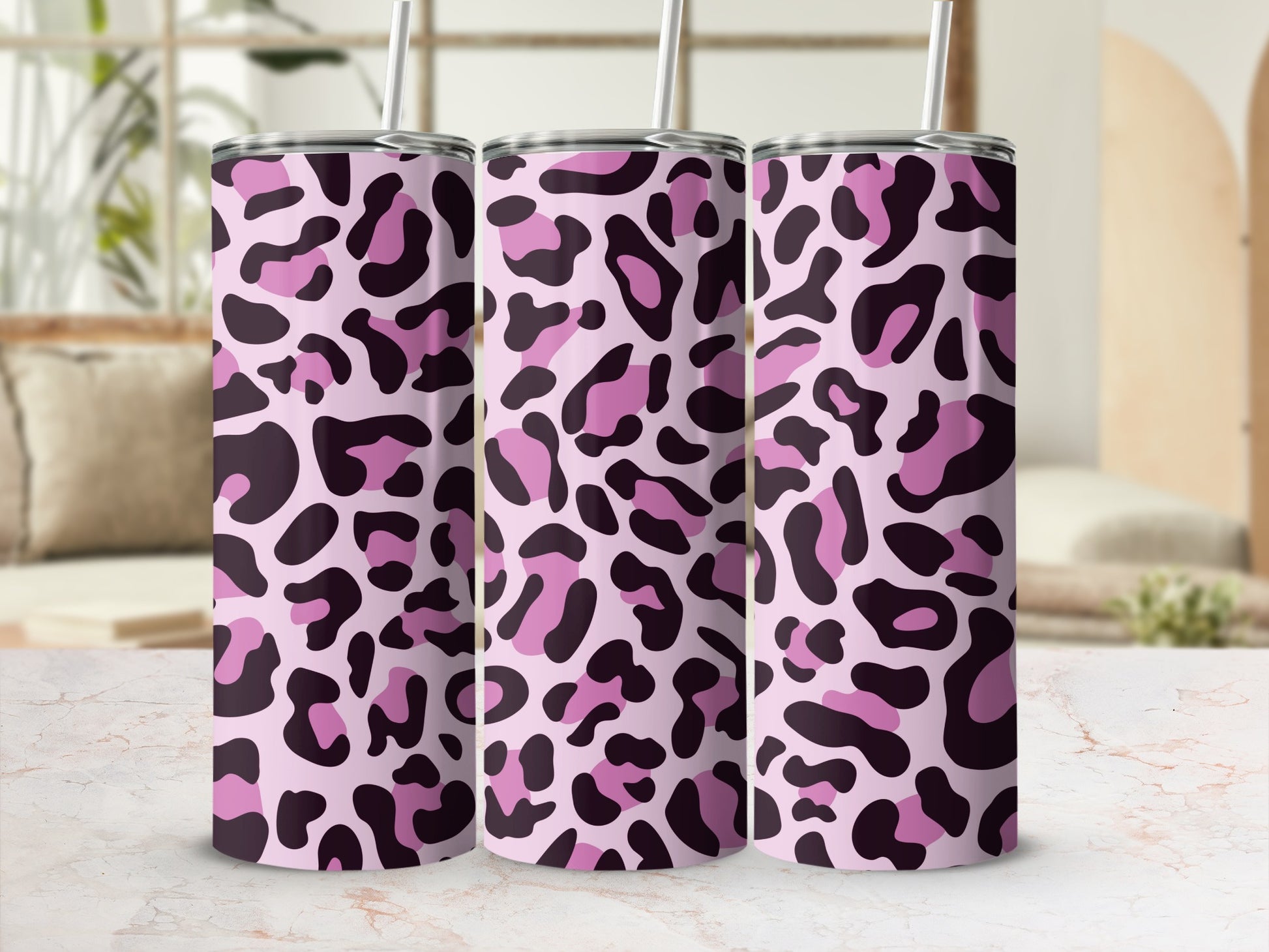 Three tumblers with pink and dark purple leopard print, each with a straw.