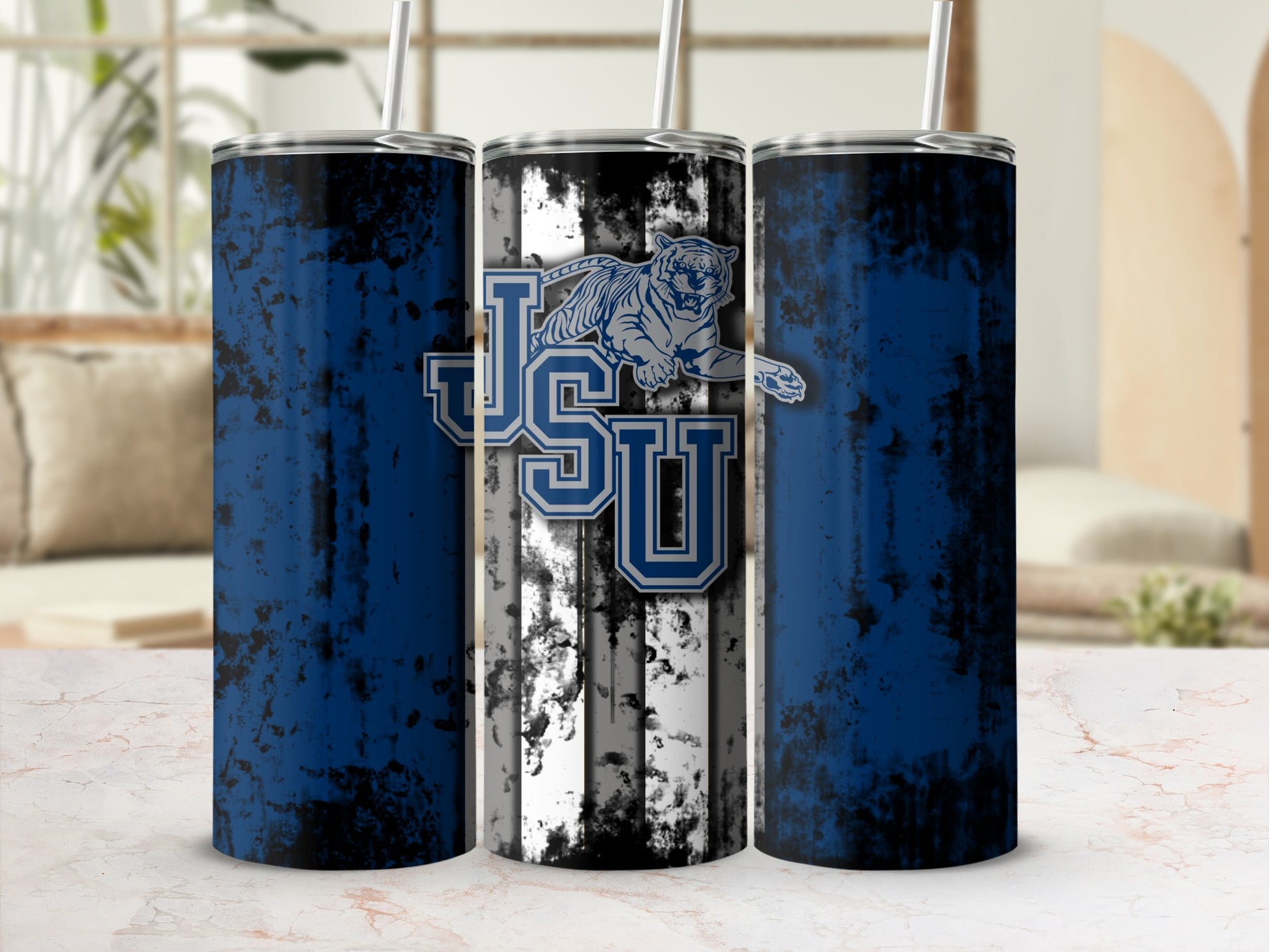 Three tumblers with a distressed blue and black design, one featuring a tiger and JSU logo.