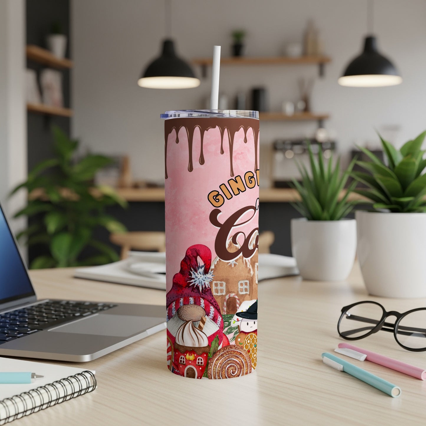 Pink tumbler with gingerbread house, gnome, and snowman Christmas designs.