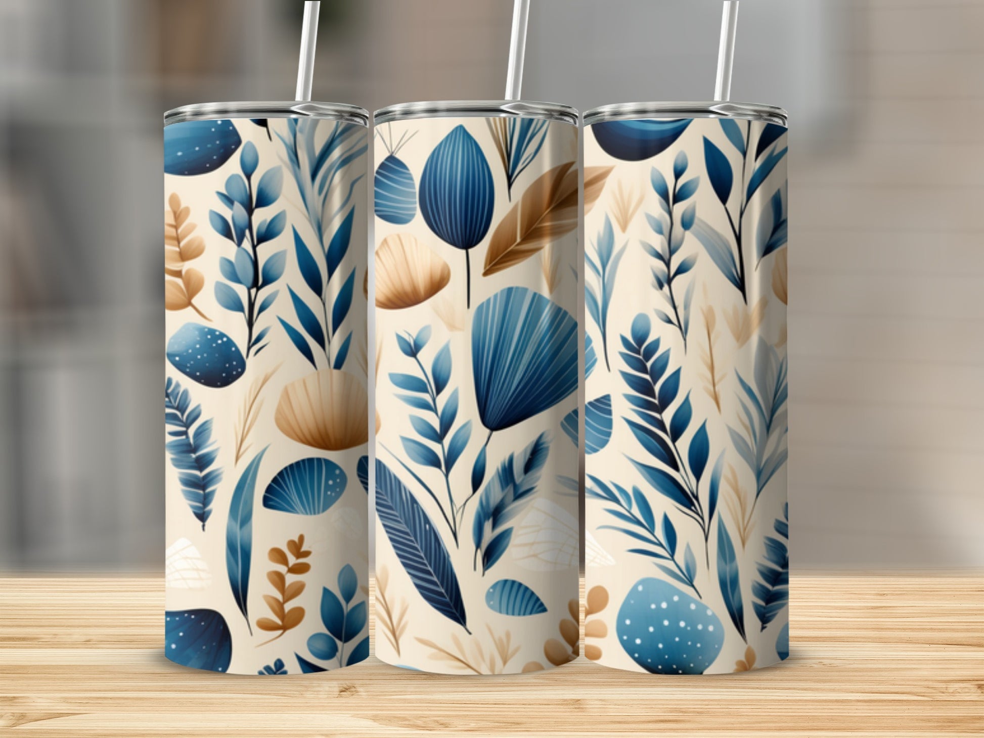 Three tumblers with a blue and tan botanical leaf pattern on a wooden surface.