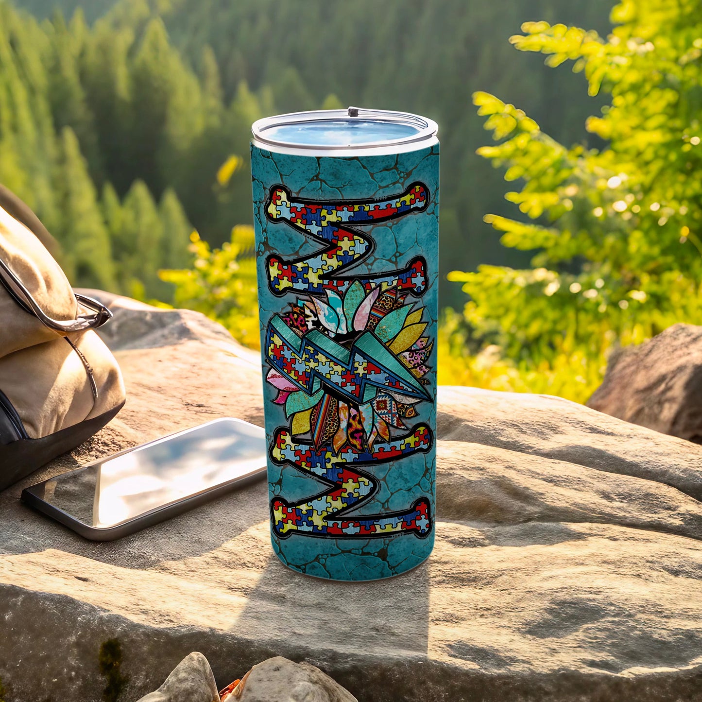 Tumbler with colorful puzzle piece pattern and airplane design on textured teal background.