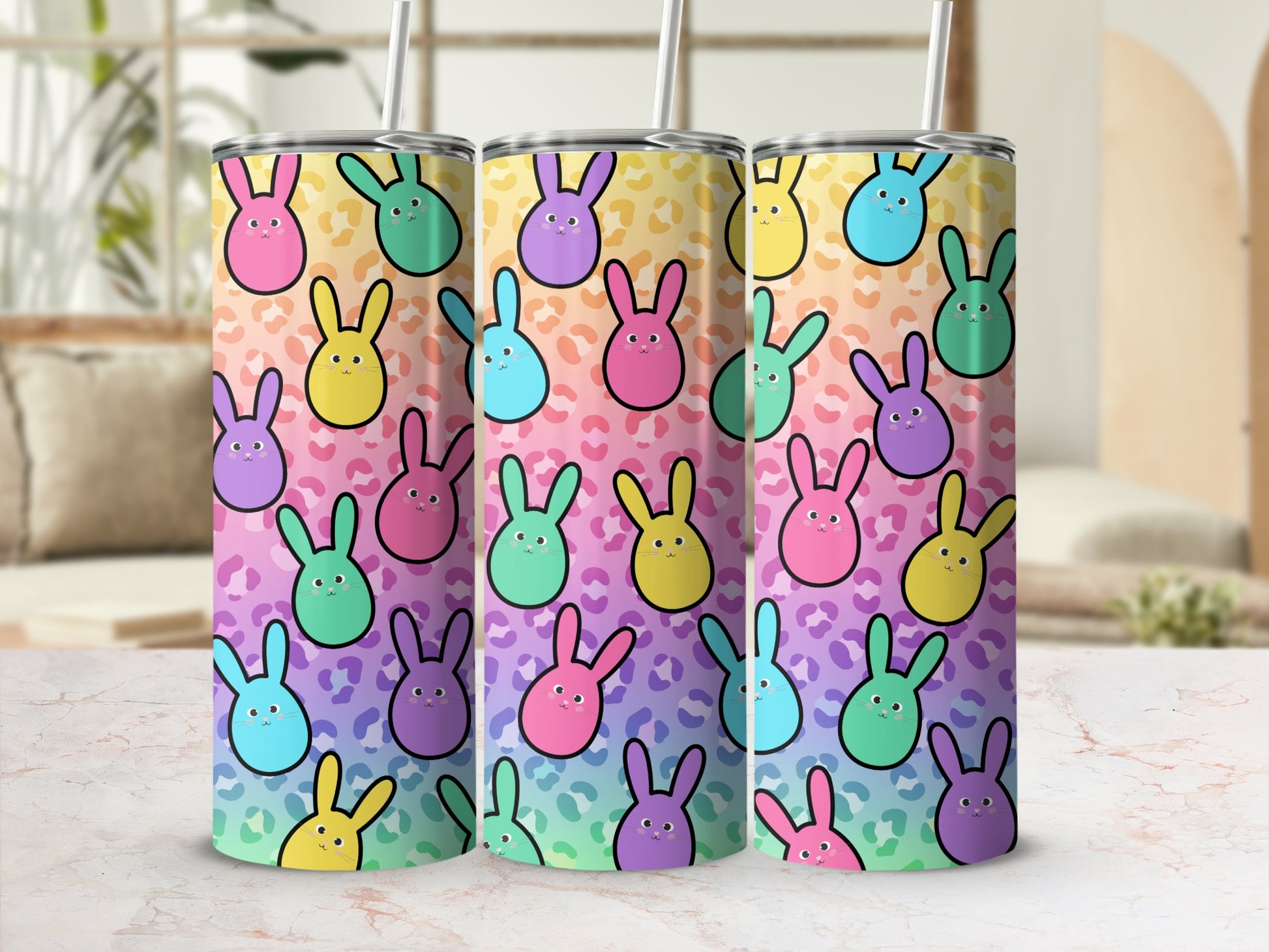 Three tumblers with a colorful bunny pattern on a counter.