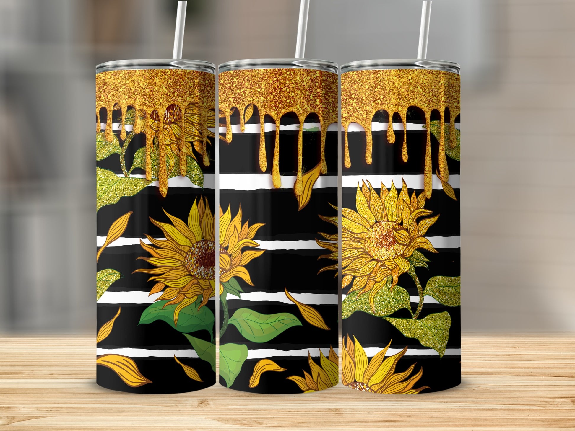 Three tumblers with sunflowers and gold glitter drip designs on striped backgrounds.