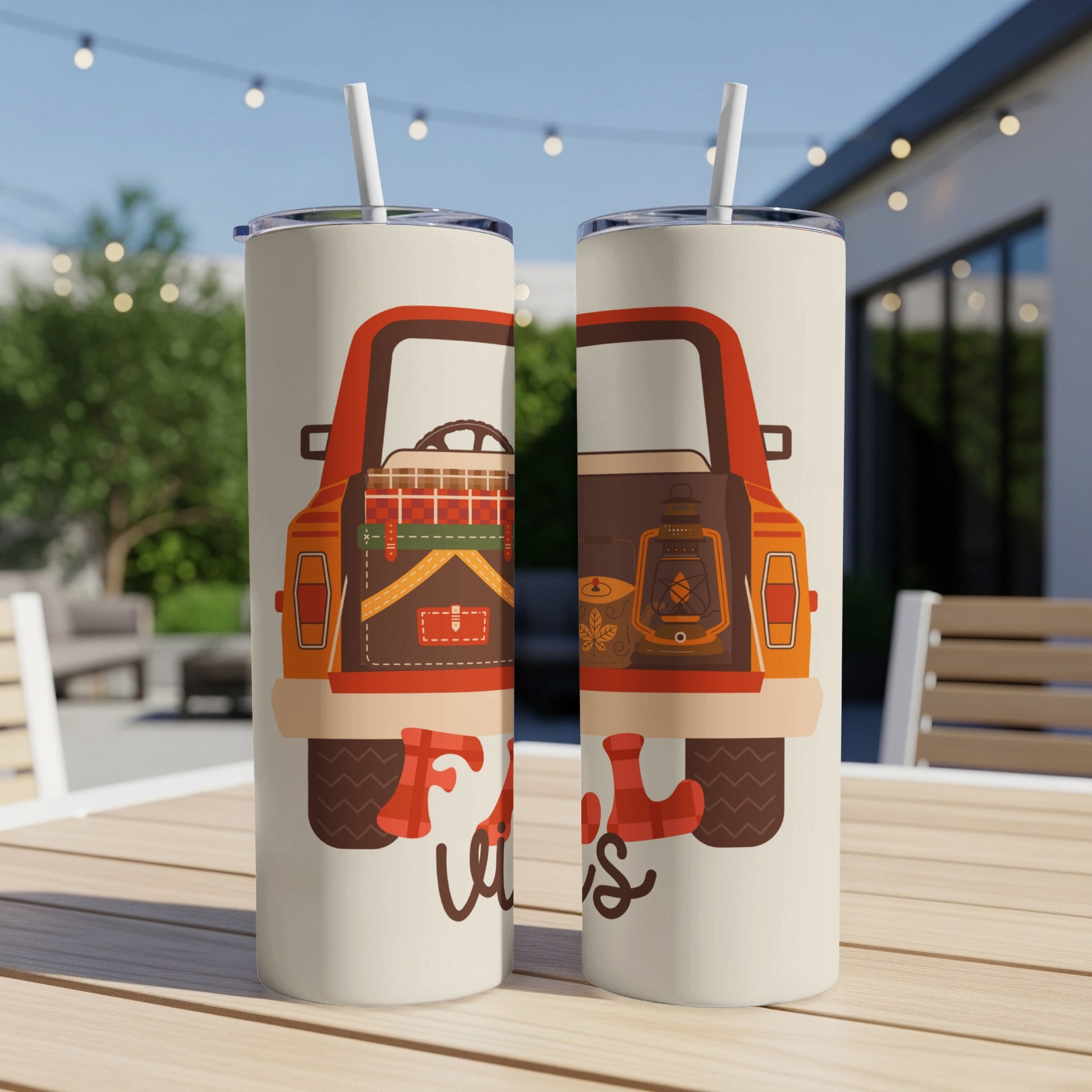 Two tumblers with a fall truck design on an outdoor table.