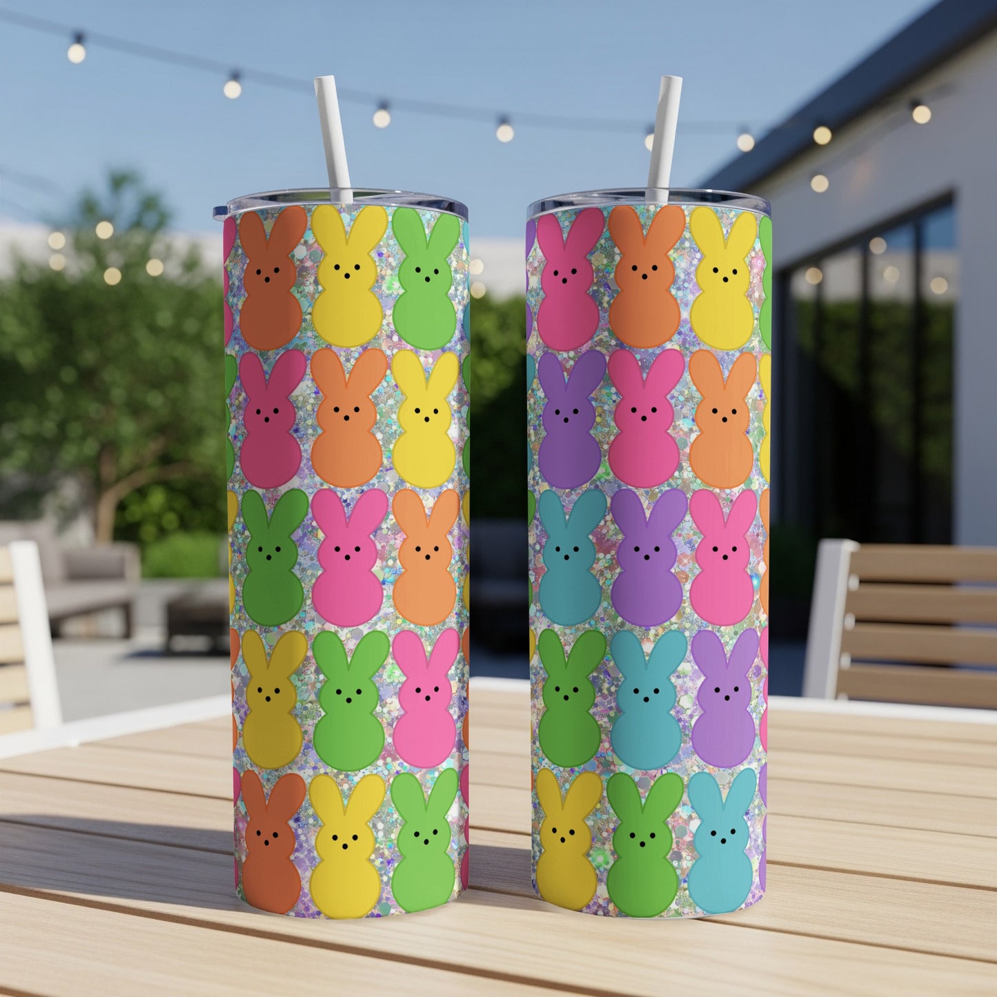 Two colorful glittery Easter bunny tumblers with straws on a wooden table.