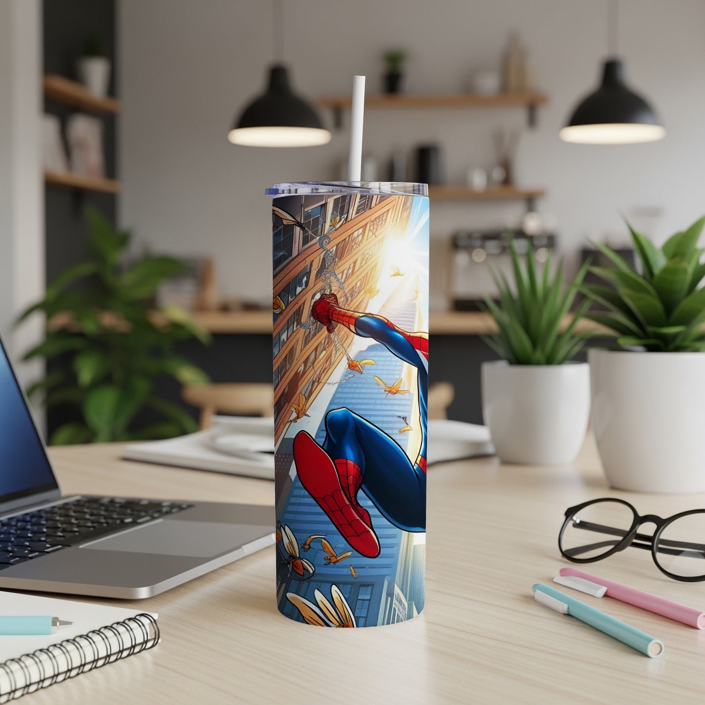 Spider-Man in action on a cityscape tumbler with straw on a desk.