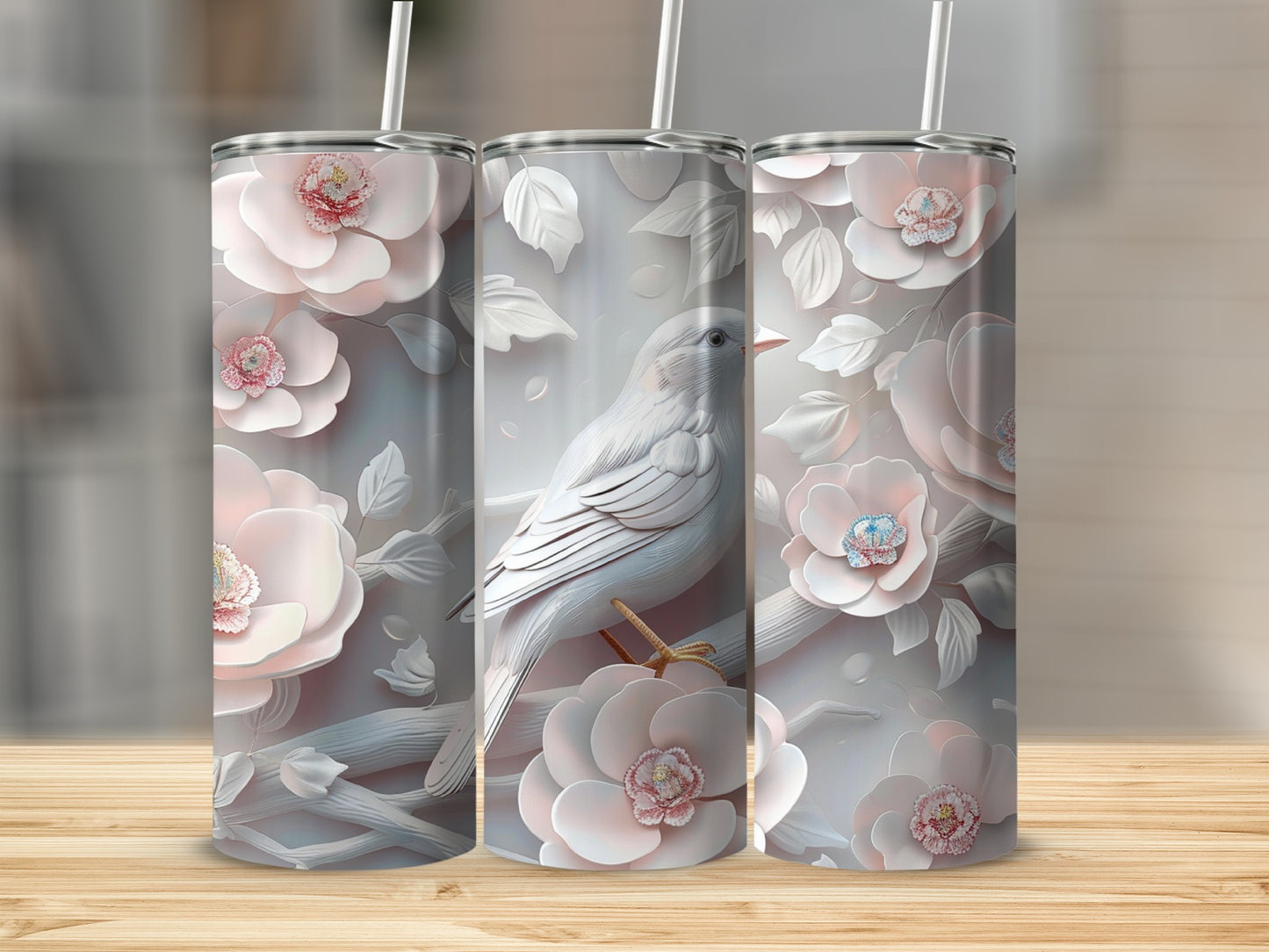 Three tumblers with white birds and pink flowers on a wooden surface.