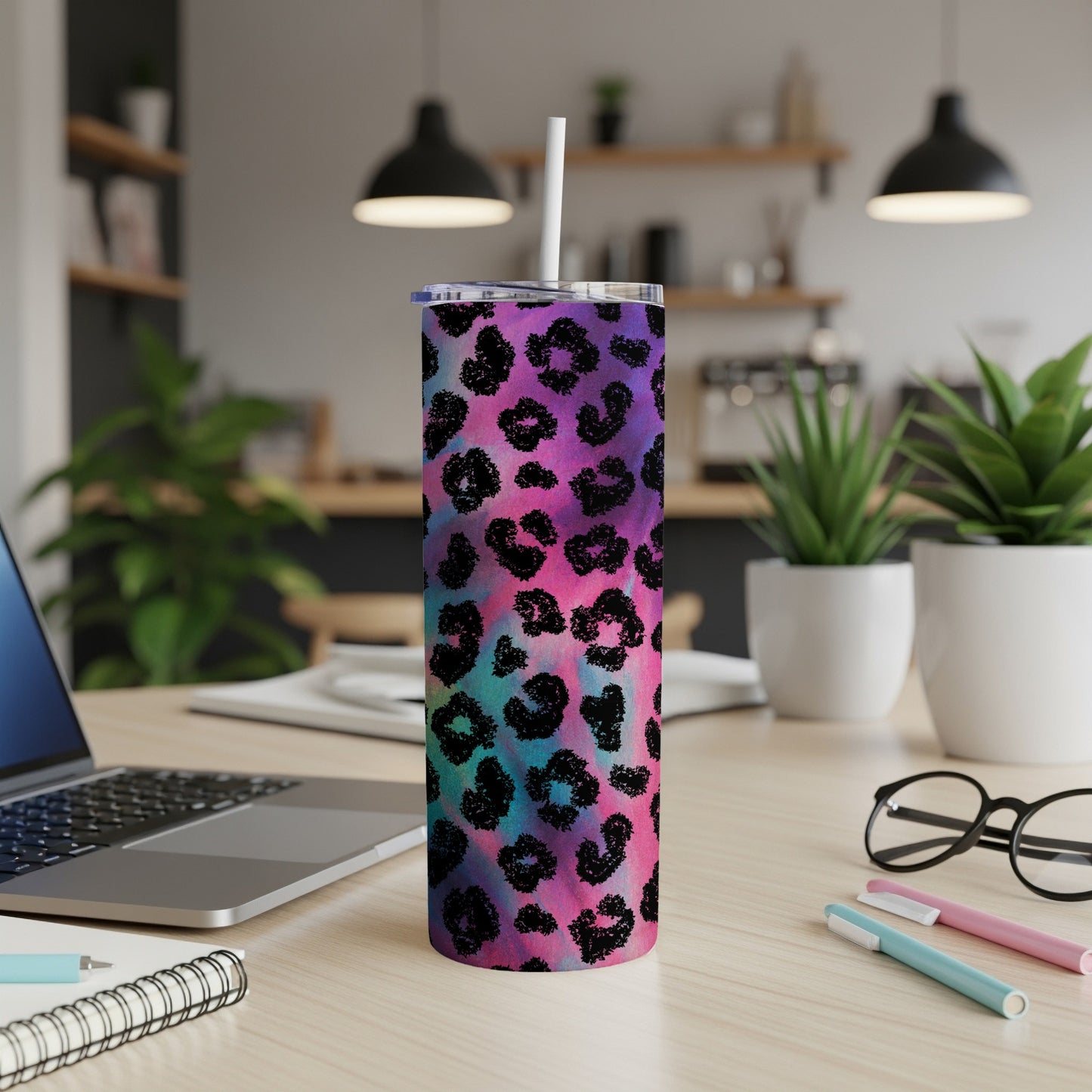 Tumbler with a black leopard print on a colorful tie-dye background.