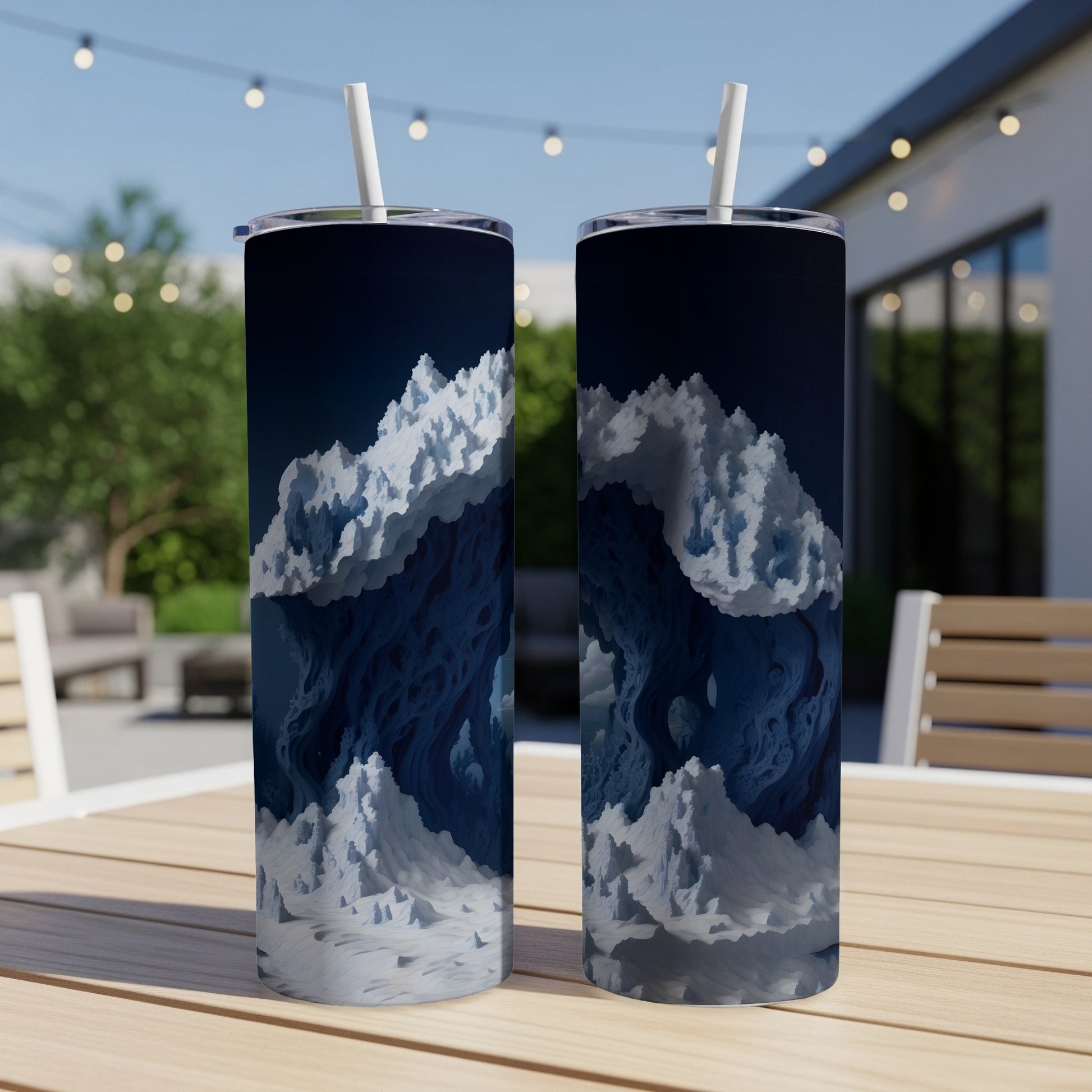 Two tumblers with abstract blue and white ice-like mountains on a table outdoors.