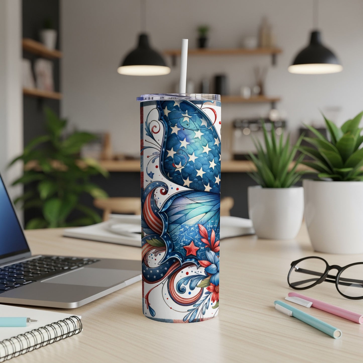 Stars and stripes tumbler with a straw on a desk.