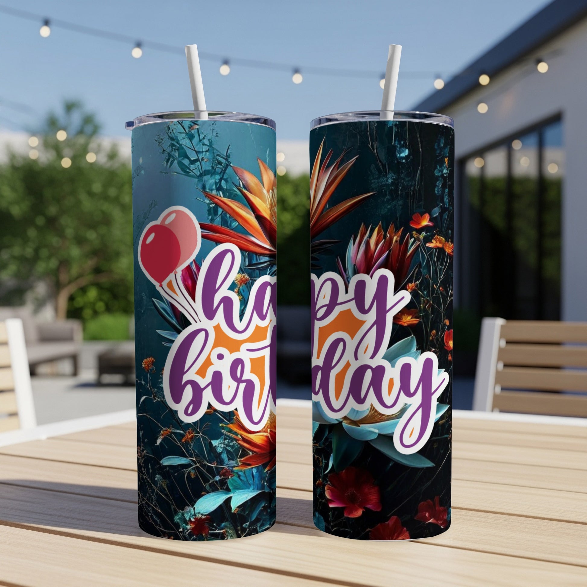 Two tumblers with "Happy Birthday" text and floral designs sit on a table.