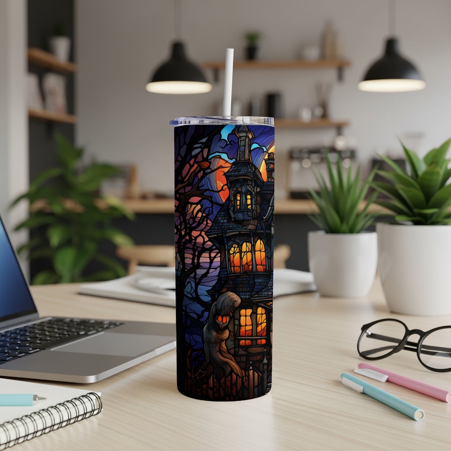 Spooky haunted house stained glass design on a white tumbler.