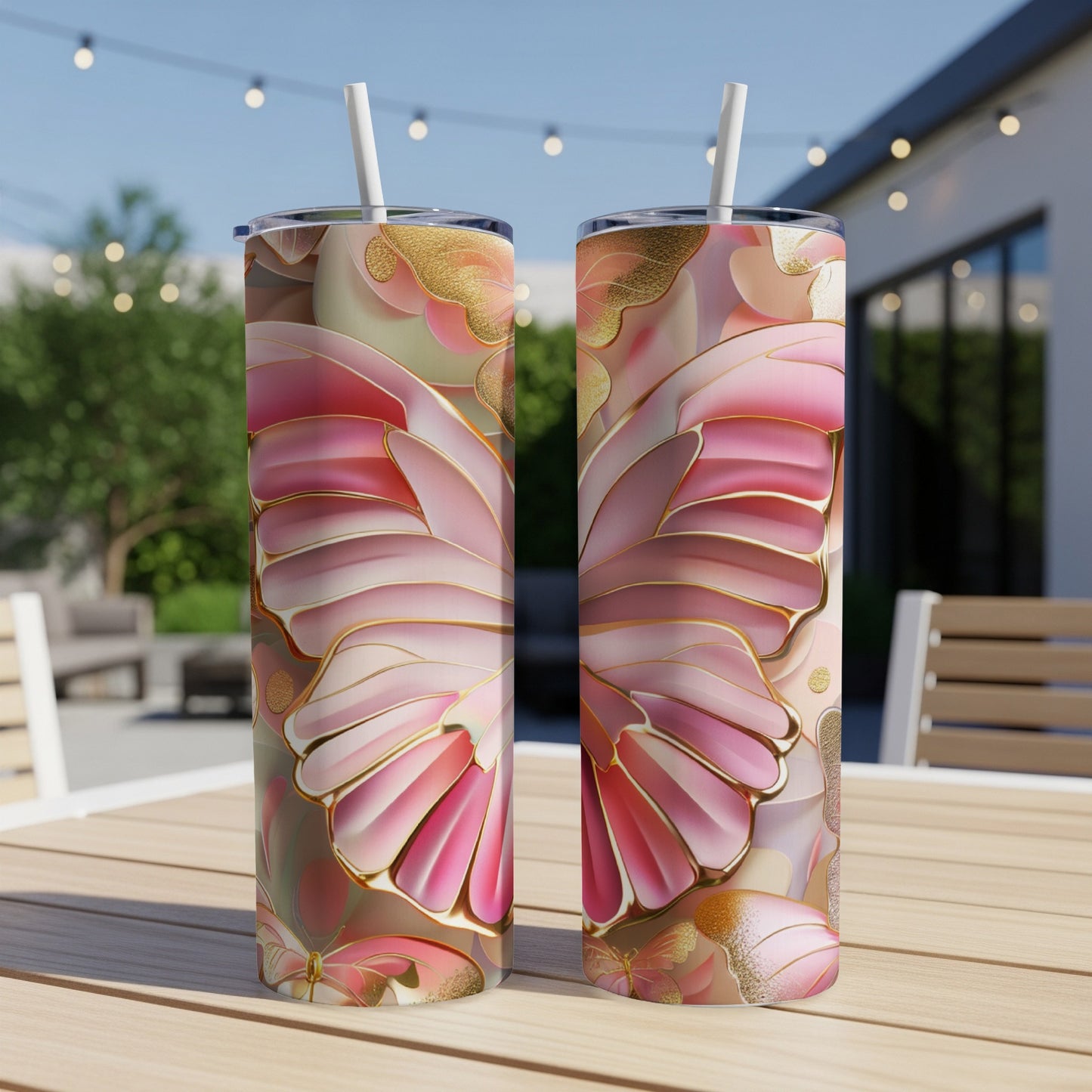 Two pink and gold butterfly wing patterned tumblers on a wooden table.