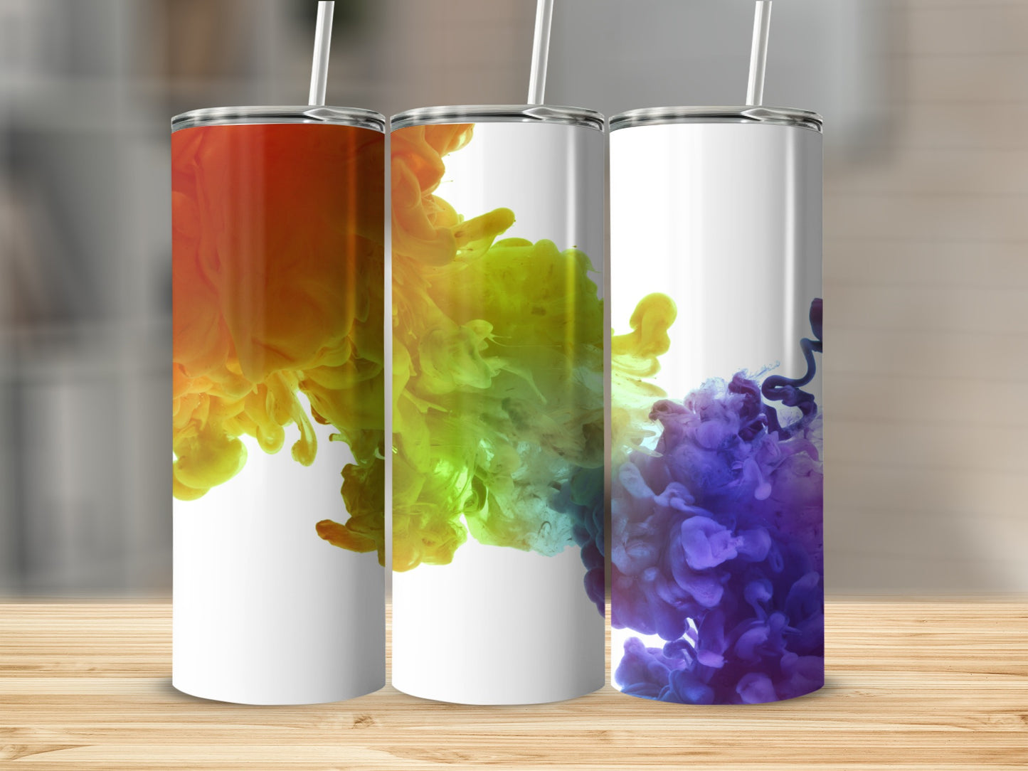 Three white tumblers with colorful ink swirls: orange, yellow, green, and purple.