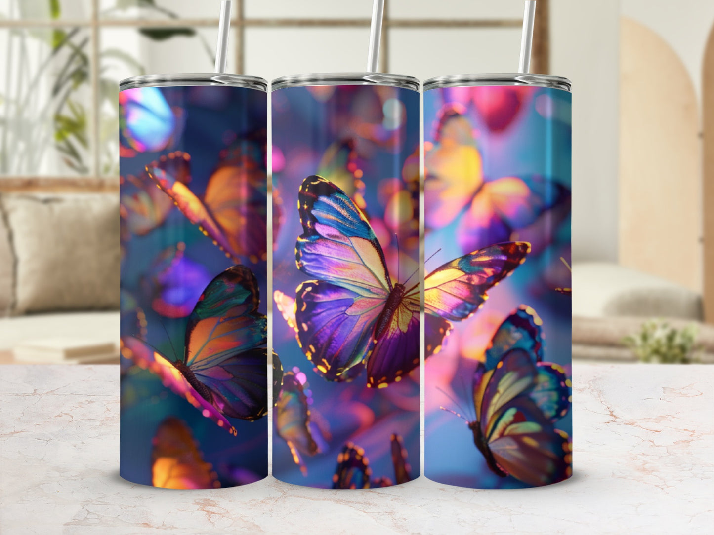 Three tumblers with iridescent butterfly patterns and straws on a marbled surface.