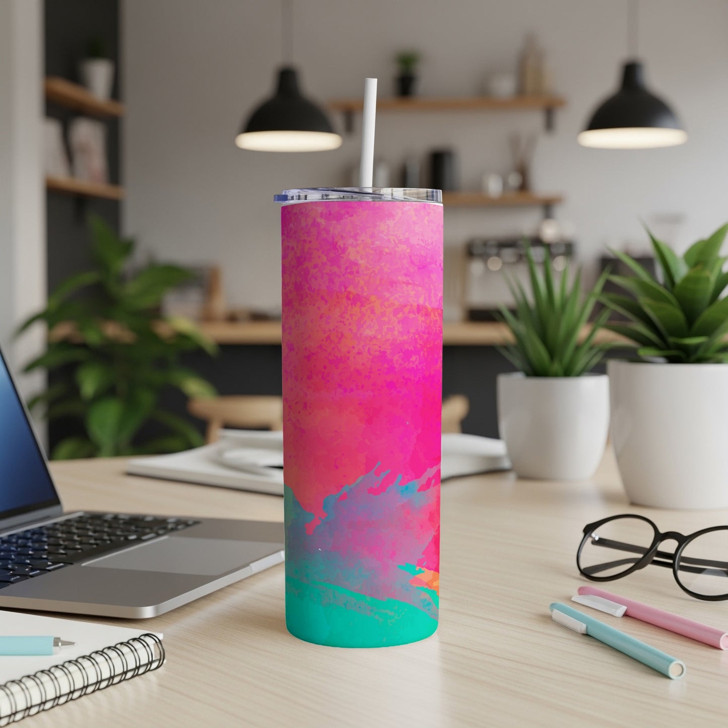 Tall tumbler with abstract pink, blue, and teal watercolor design and straw.